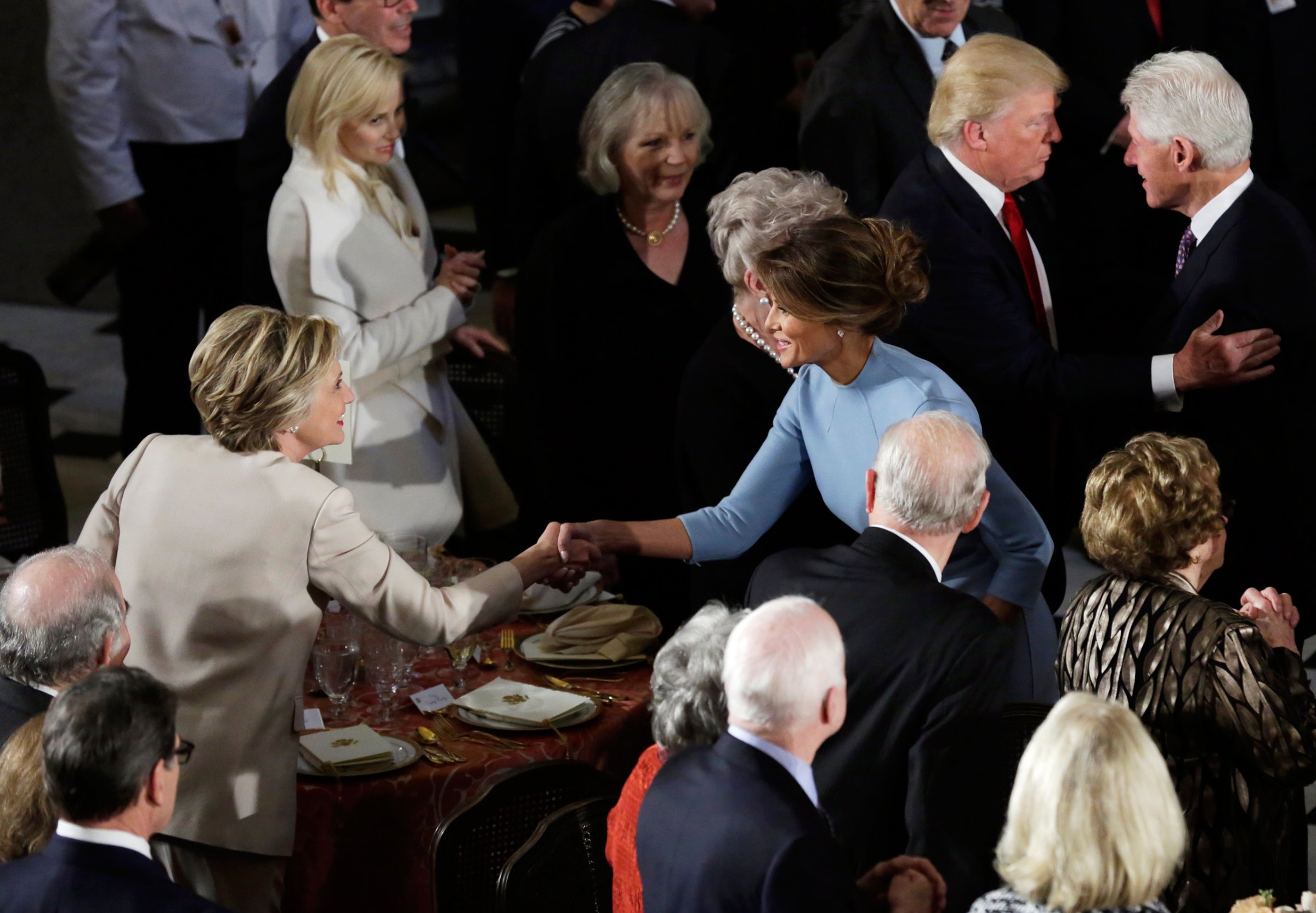 Former Democratic U.S. presidential nominee Hillary Clinton greets First lady Melania Trump as her husband Bill Clinton speaks with President Donald Trump during the Inaugural luncheon at the National Statuary Hall in Washington, U.S, January 20, 2017. REUTERS/Yuri Gripas - RTSWJZE