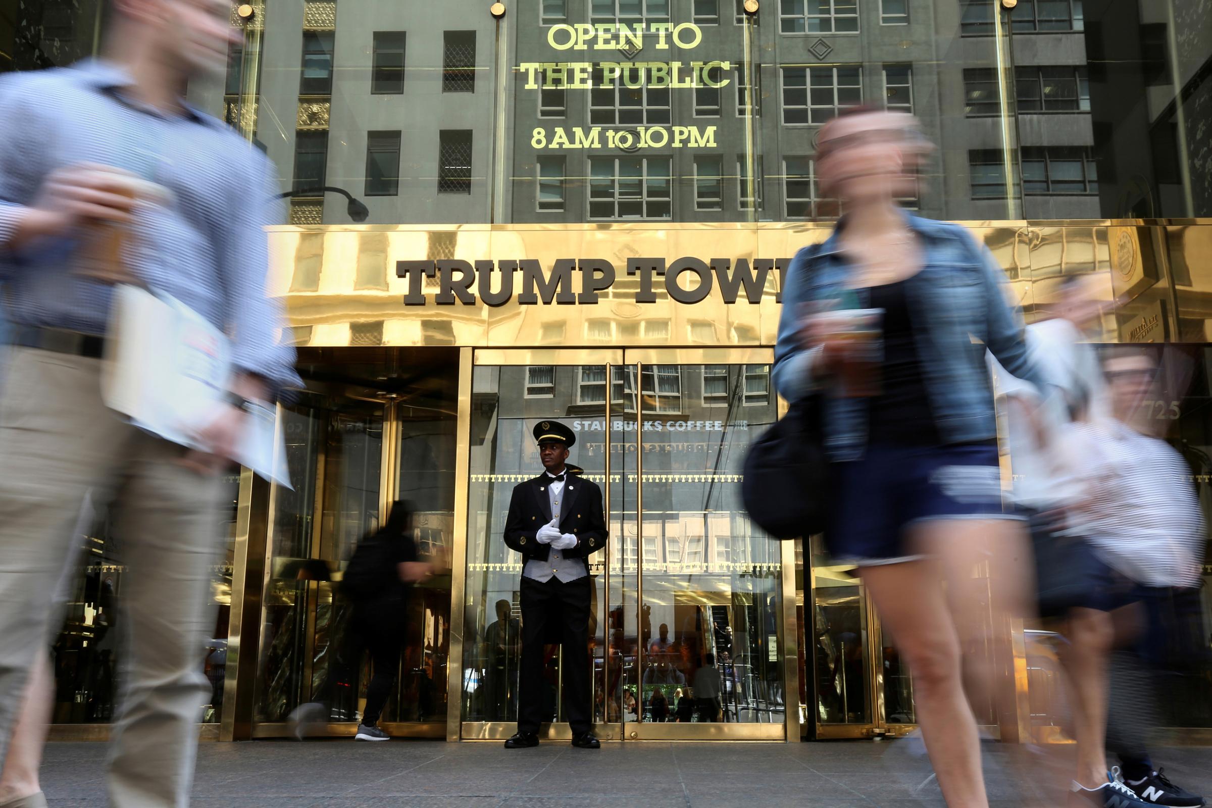 A doorman stands as A doorman stands as people walk past the Trump Tower in New York, U.S., May 23, 2016. REUTERS/Carlo Allegri/File Photo - RTX2F1V0