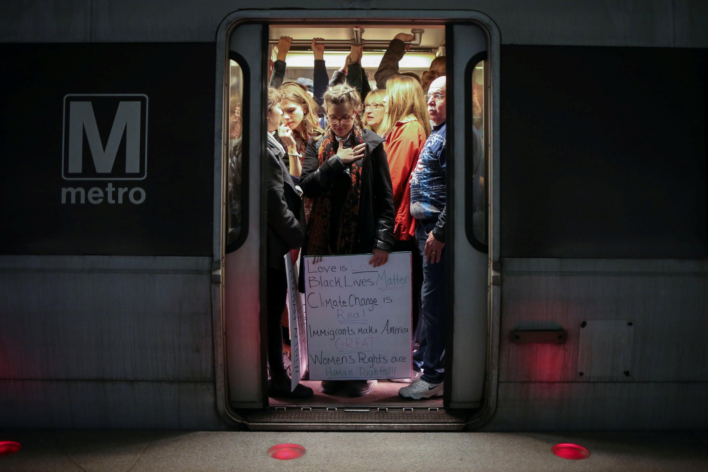 A woman activist holds placard on Metrorail on way to Women's March in Washington, D.C.