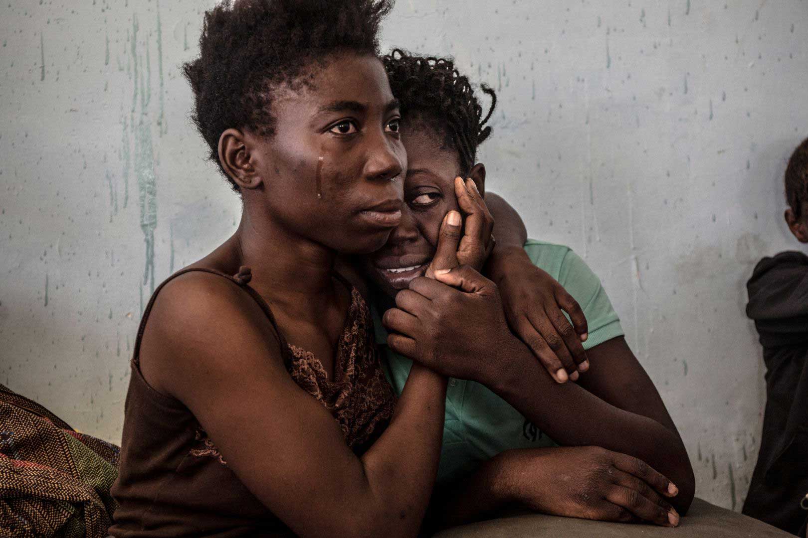 Two Nigerian refugees cry and embrace in a detention center for refugees in Surman, Libya, on Aug. 17, 2016.