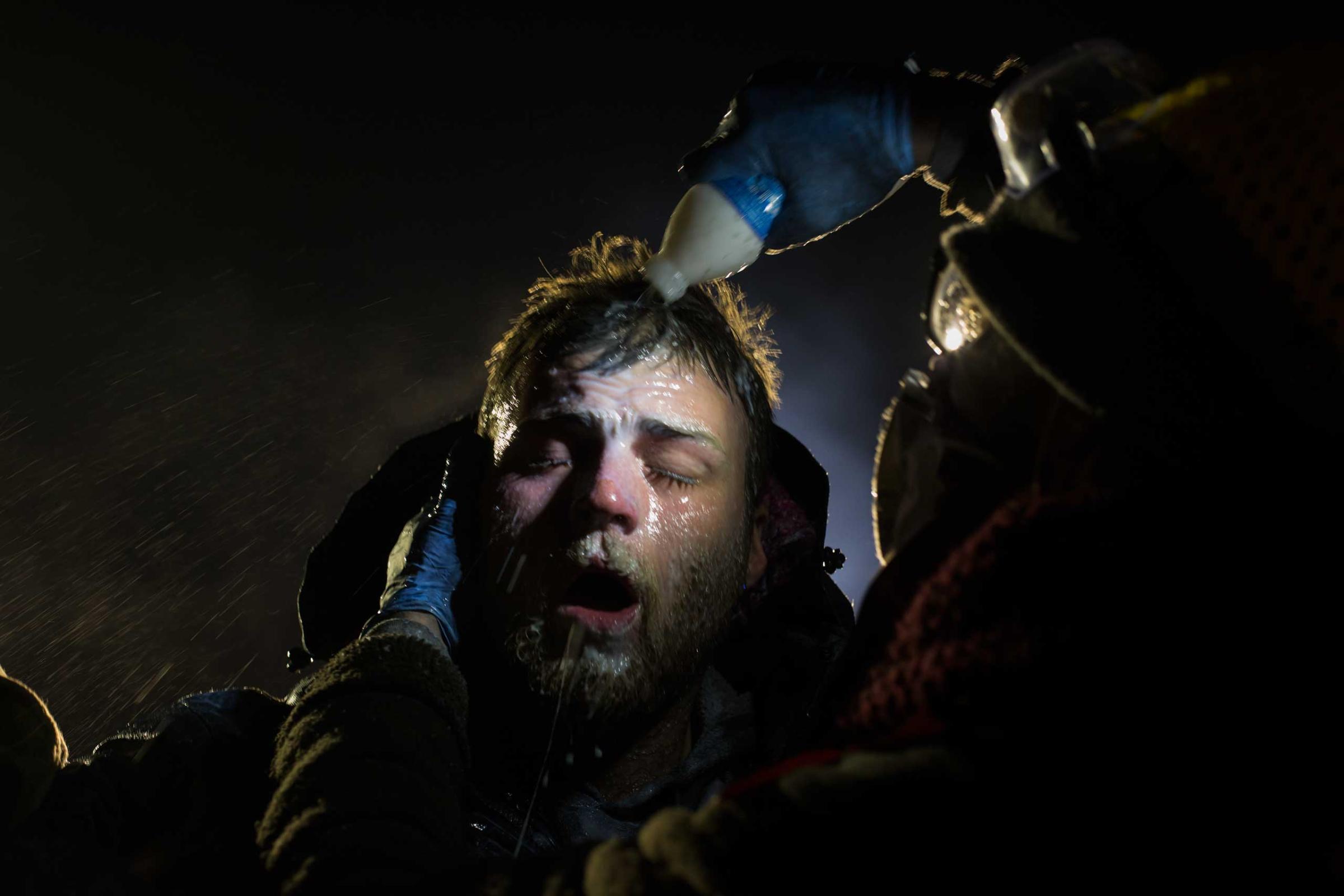 Healers - A man is treated after being pepper sprayed by police. White people have joined the camps in large numbers, often standing in front of indigenous protestors to shield them with their bodies. A man is treated with milk of magnesia after being pepper sprayed at the police blockade on highway 1806 near Cannon Ball, North Dakota on Sunday, November 20, 2016. Many people were injured when, with temperatures below freezing, police deployed water canons, pepper spray, tear gas, rubber bullets and percussion grenades. Amber Bracken