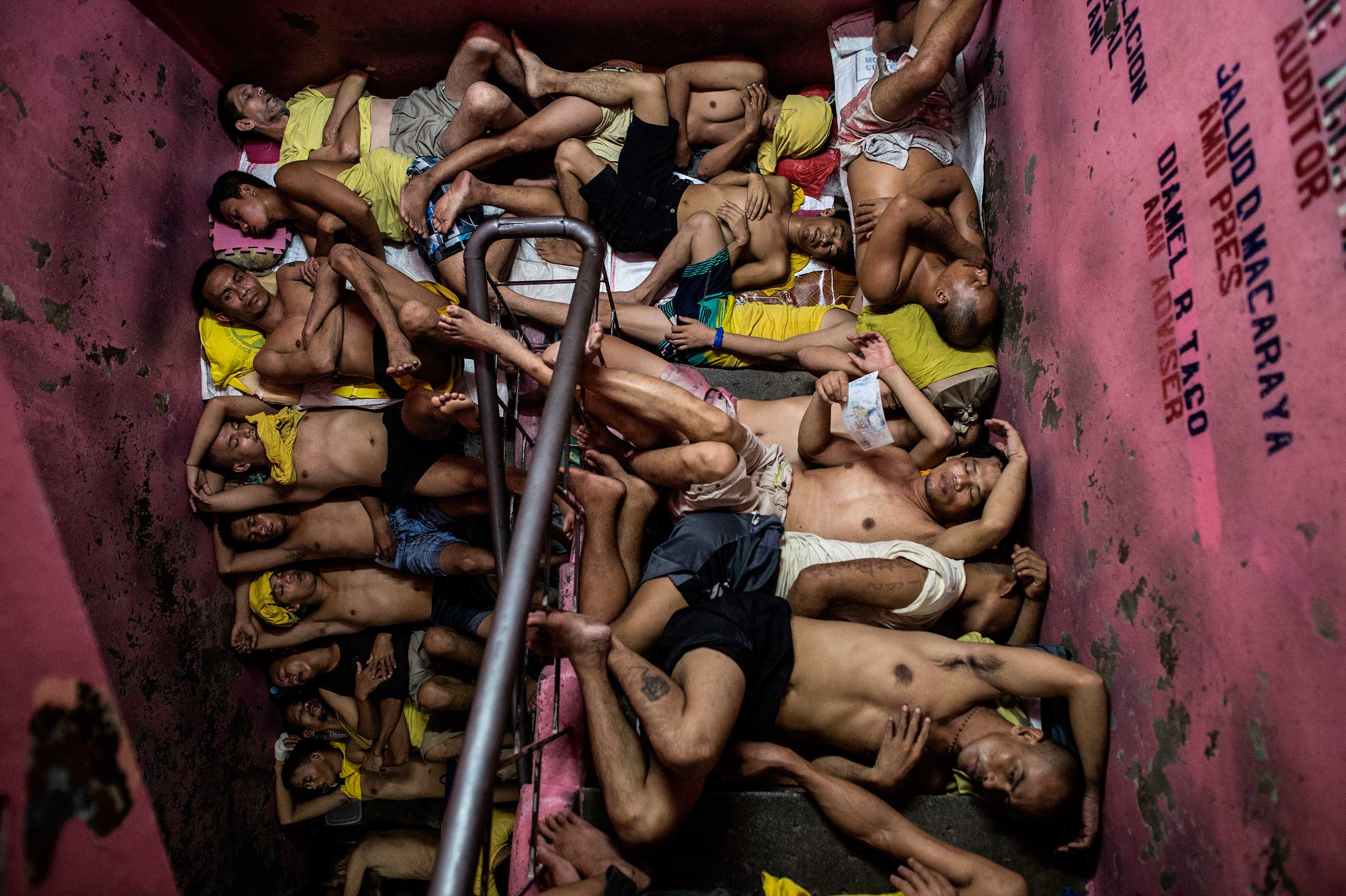Inmates sleep on the steps of a ladder inside the Quezon City jail at night in Manila. July 21, 2016.
