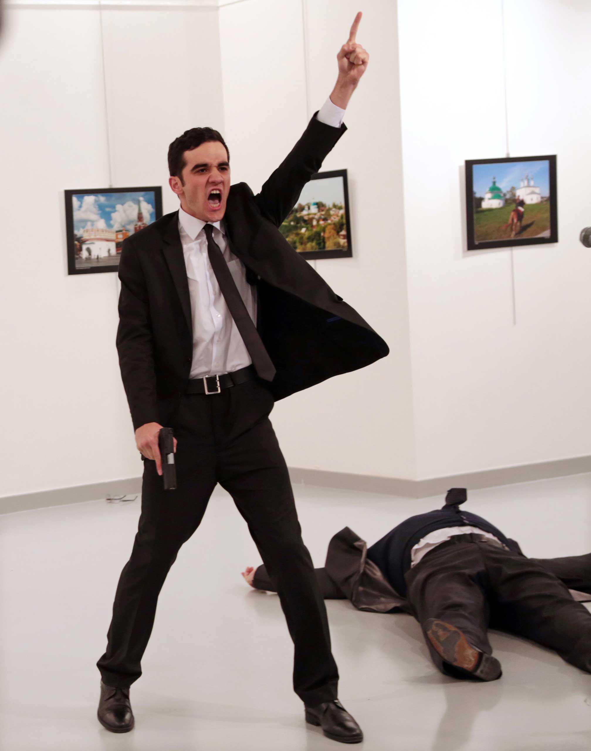 Mevlut Mert Altintas shouts after shooting Andrei Karlov, right, the Russian ambassador to Turkey, at an art gallery in Ankara, Turkey, Dec. 19, 2016.