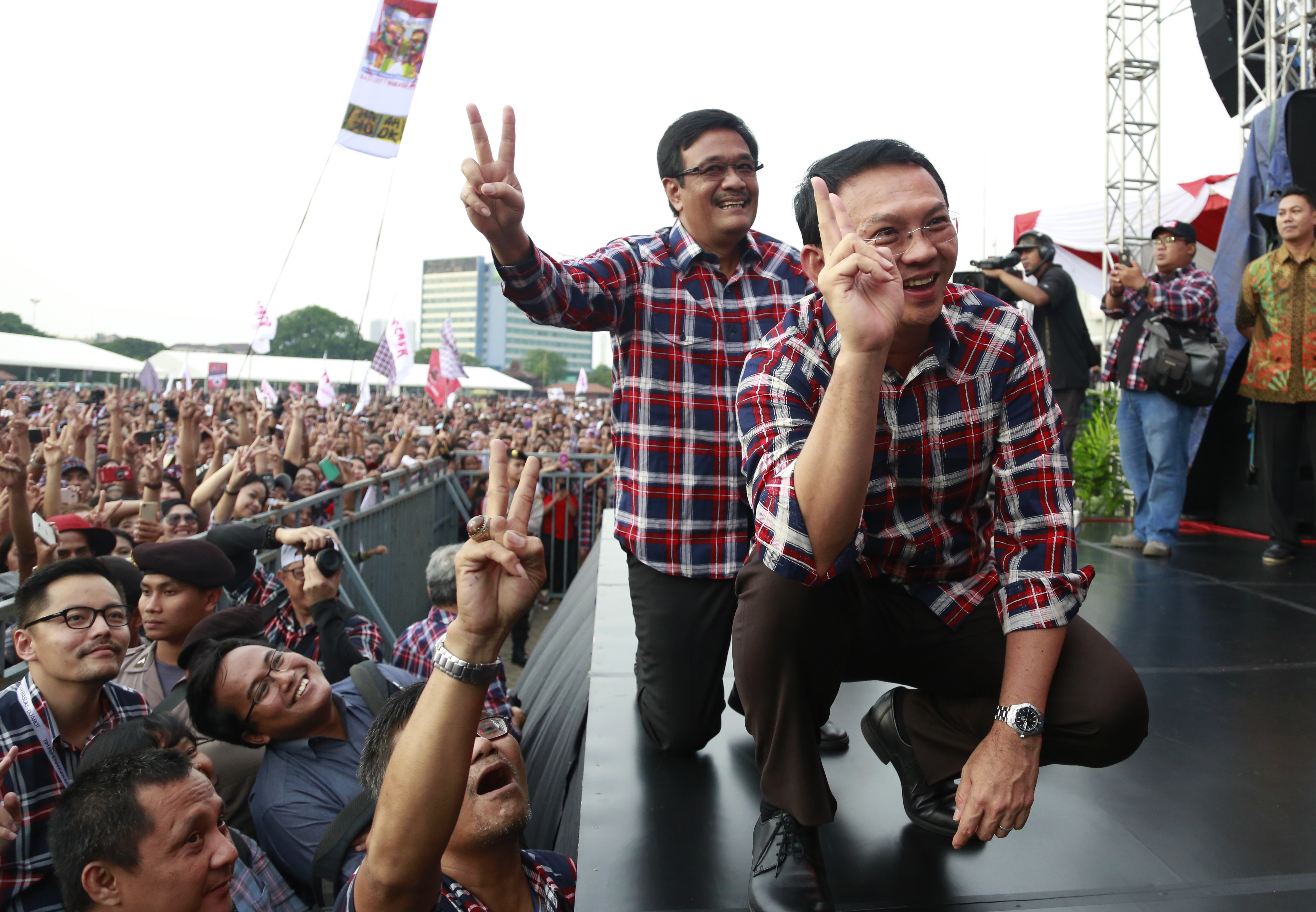 Jakarta Governor Basuki Tjahaja Purnama, also known as Ahok, right, and his deputy and also running mate, Djarot Saiful Hidayat, pose for photographers as they attend a campaign rally in Jakarta on Feb. 11, 2017 (Dita Alangkara—AP)