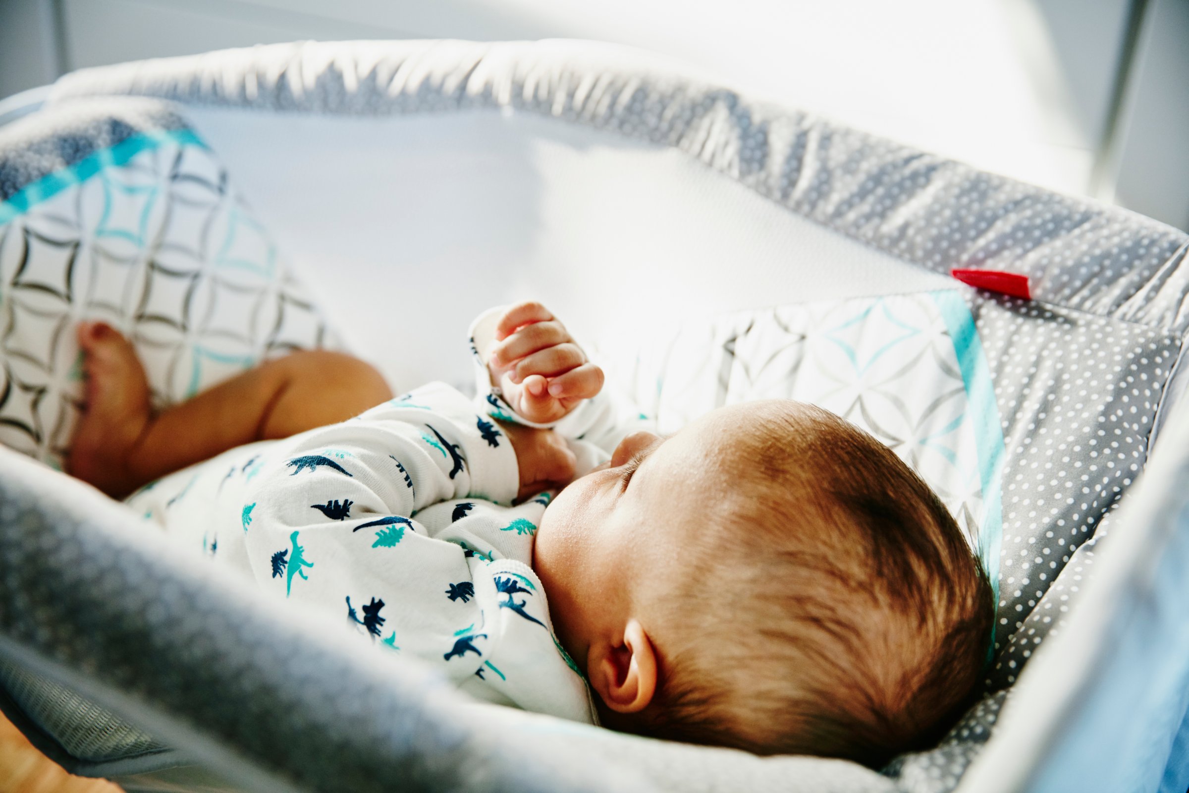 Infant lying in bassinet in home