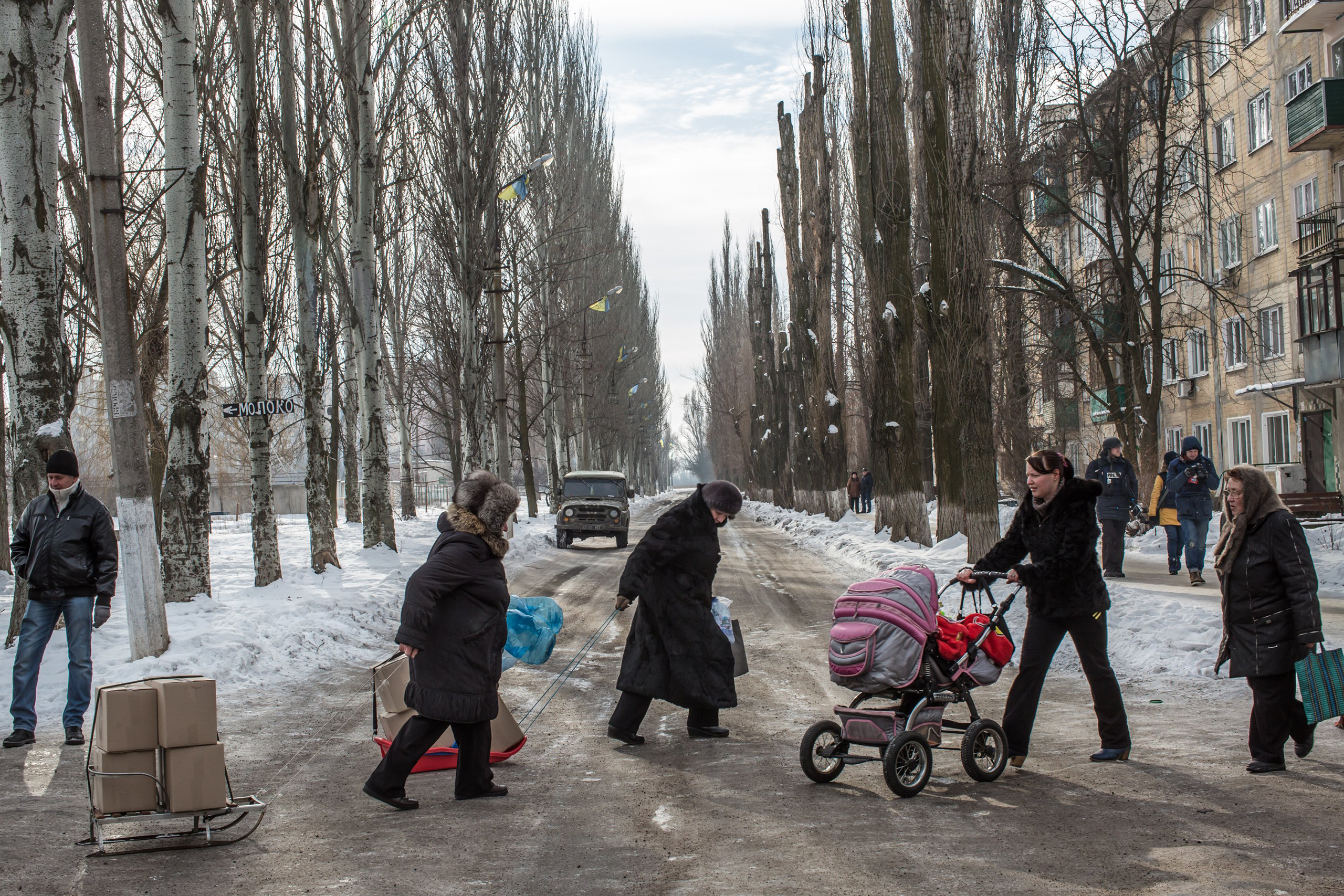 Residents carry boxes of humanitarian aid on sleds across the street after a night of shelling in Avdiivka, Ukraine, on Feb. 1, 2017. (Brendan Hoffman—Getty Images)