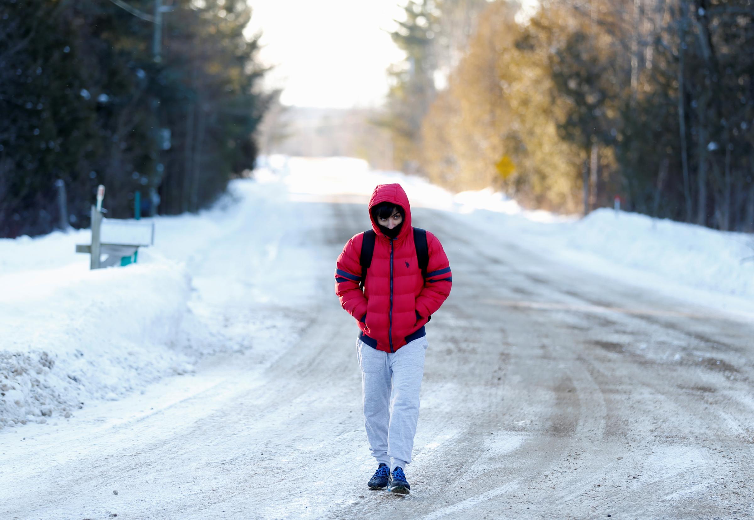 A man who said his name was Abdullah and that he was a student from Yemen walks towards the U.S.-Canada border to cross into Hemmingford, Canada, from Champlain in New York, U.S., February 17, 2017. REUTERS/Christinne Muschi - RTSZ6Q3
