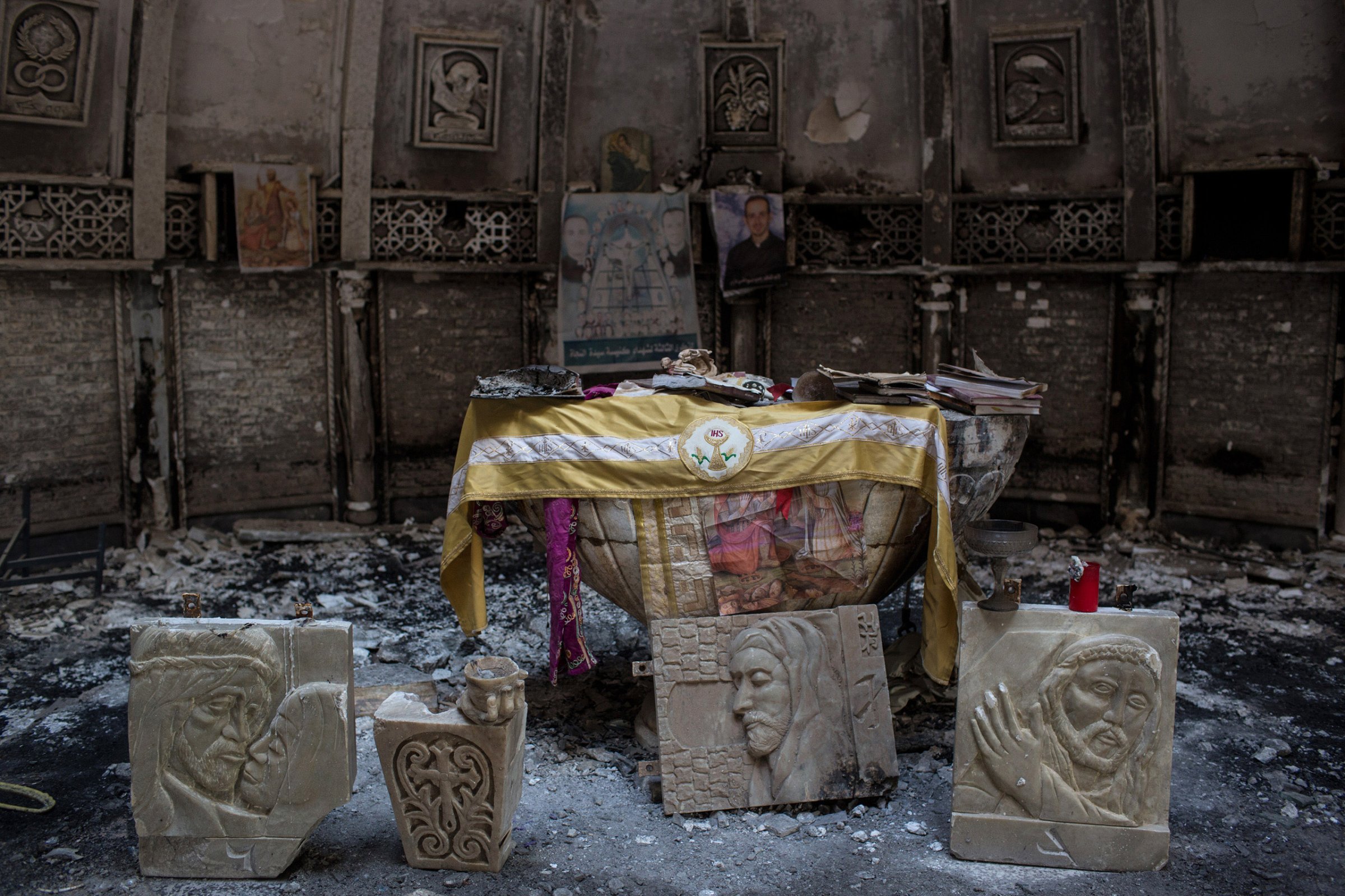 Salvaged books and other items are placed around the altar of a church, burned and destroyed by ISIS during the group's occupation of the predominantly Christian town of Qaraqosh, Iraq, on Dec. 27, 2016.