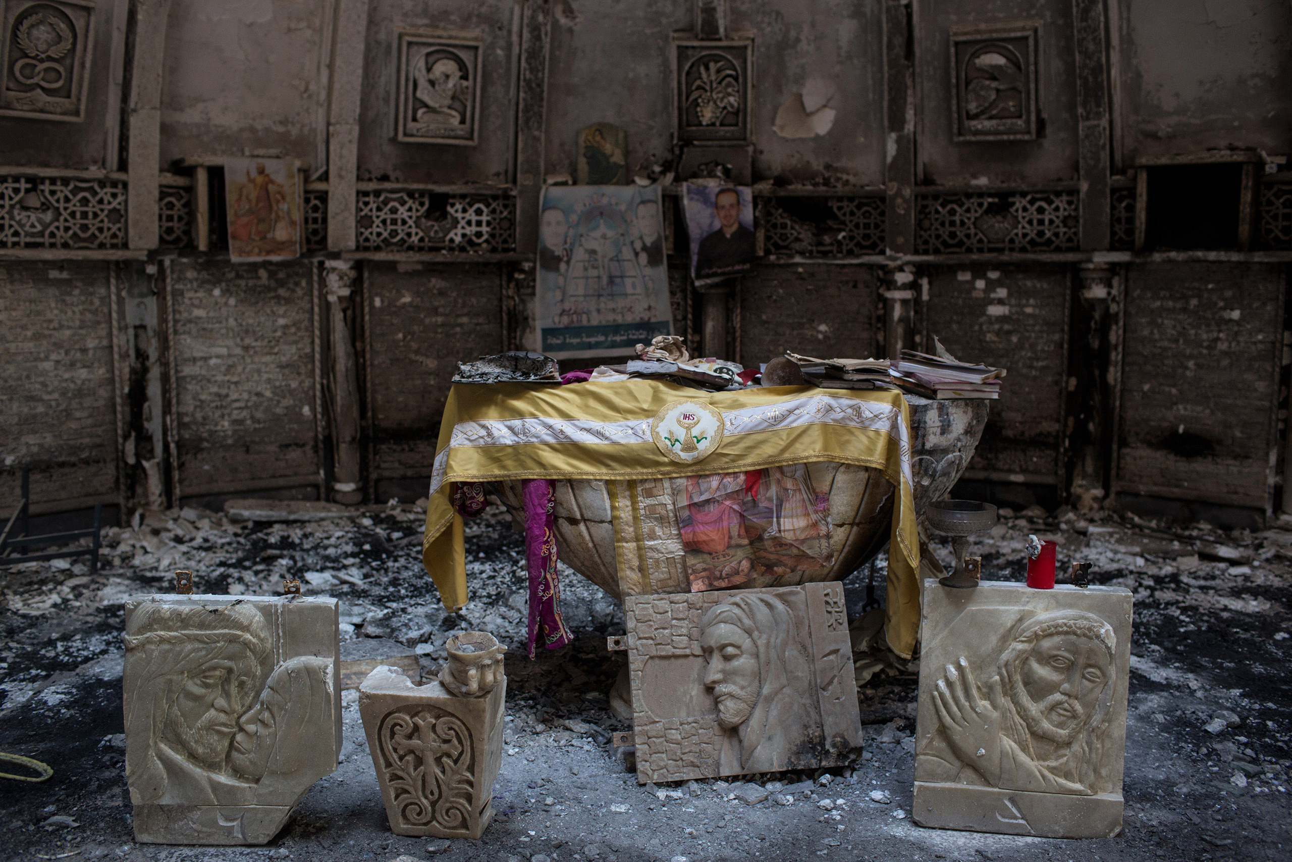 Salvaged books and other items are placed around the altar of a church, burned and destroyed by ISIS during the group's occupation of the predominantly Christian town of Qaraqosh, Iraq, on Dec. 27, 2016. (Chris McGrath—Getty Images)