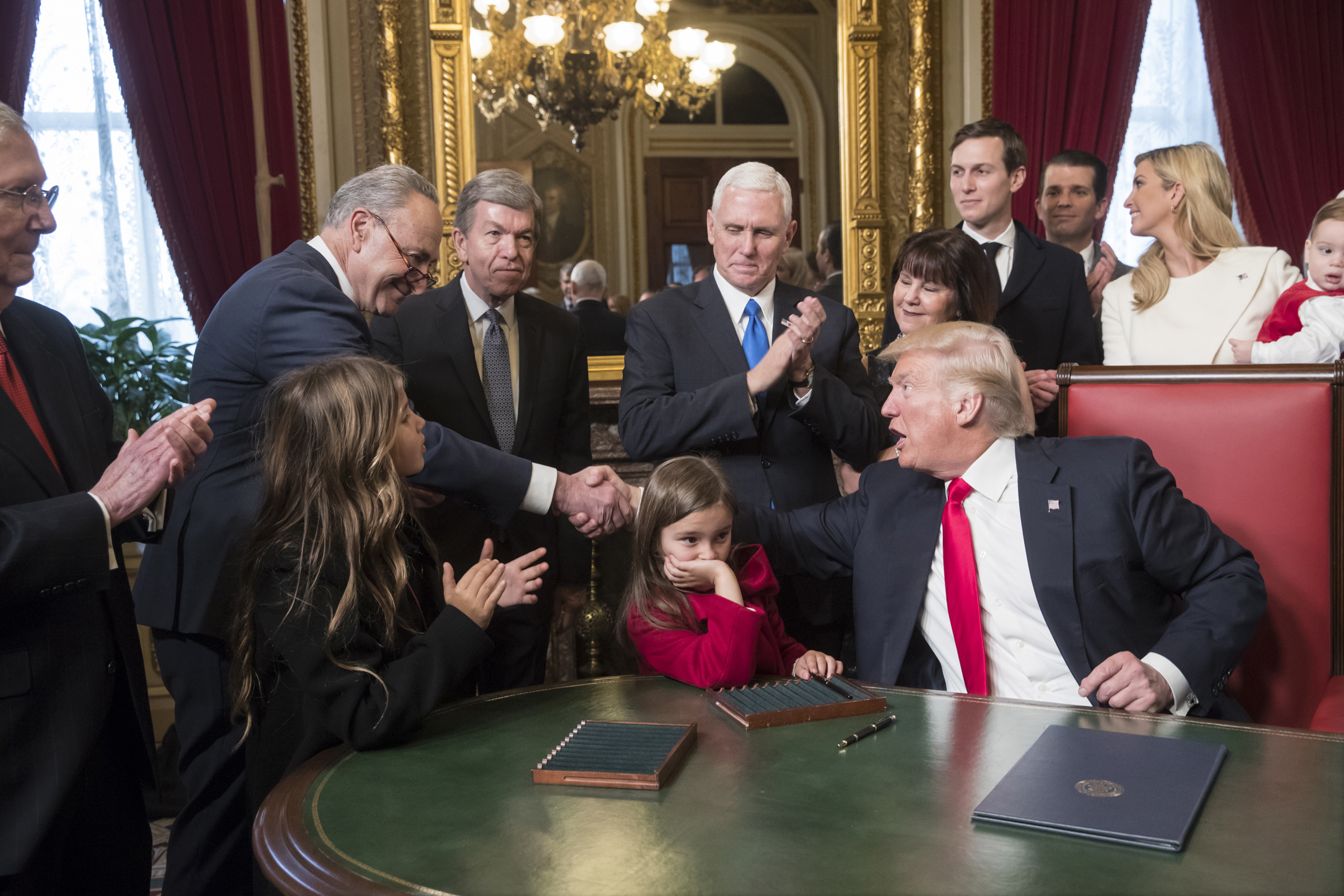 President Donald Trump shakes hands with Senate Minority Leader Charles Schumer of N.Y, as he is joined by the Congressional leadership and his family while he formally signs his cabinet nominations into law, Jan. 20, 2017. (J. Scott Applewhite—AP/Pool)