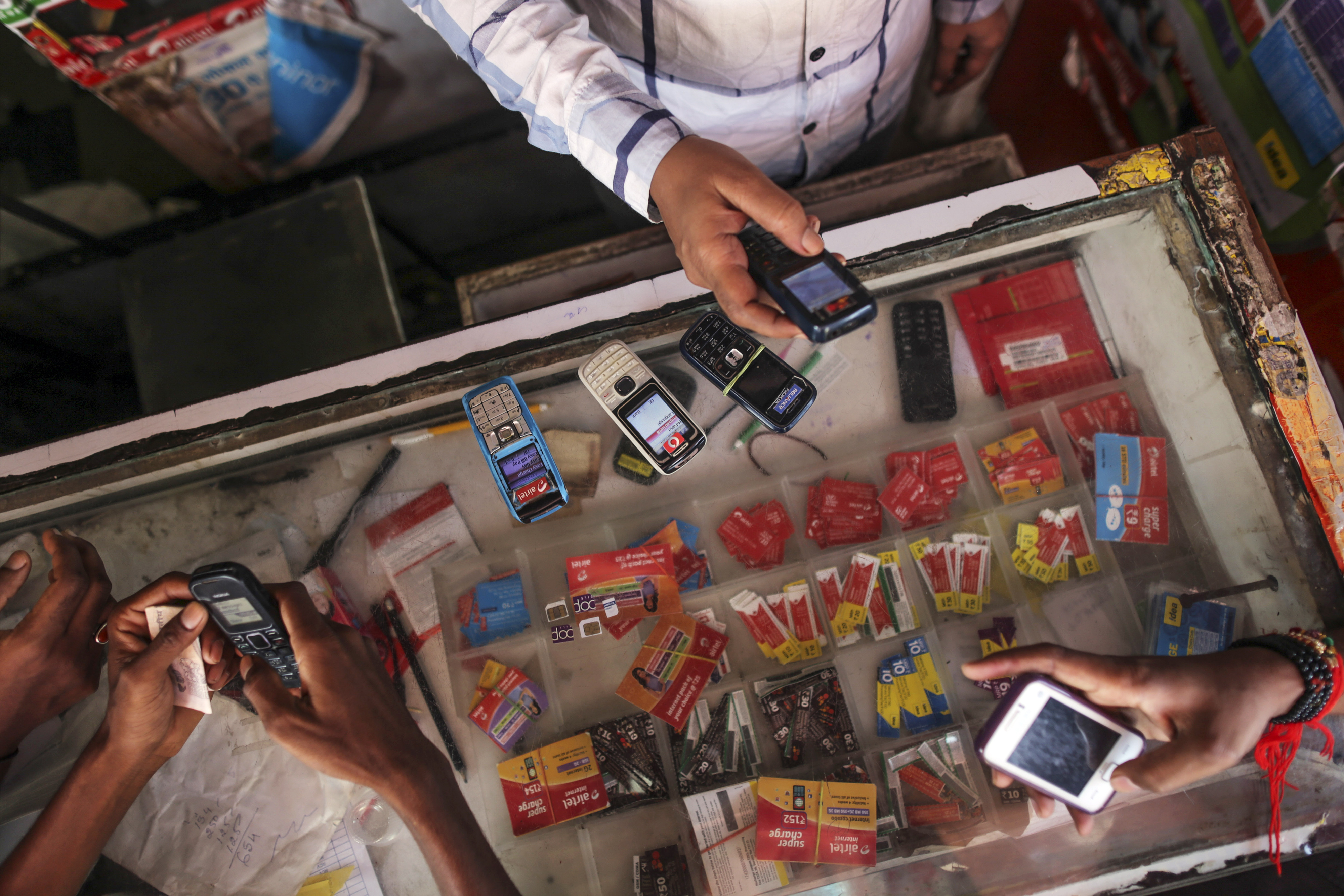 Customers wait to recharge their mobile phones at a mobile-phone store in Mumbai on Aug. 12, 2014 (Dhiraj Singh—Bloomberg/Getty Images)