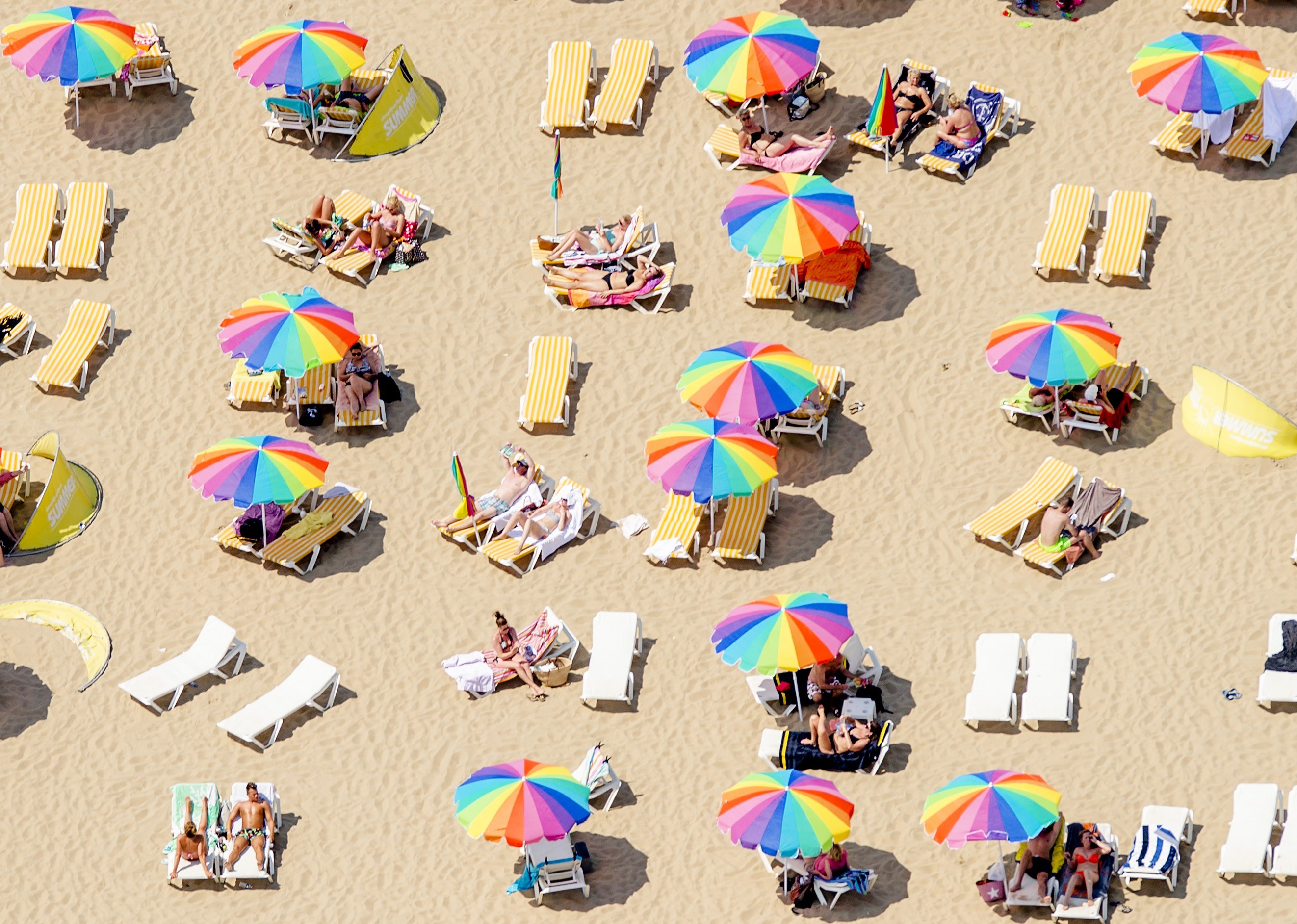 An aerial view shows sunbathers sitting under colorful umbrellas on the beach in Scheveningen, the Netherlands, on July 1, 2015, on a warm summer day. (Robin Van Lonkhuijsen&mdash;AFP/Getty Images)
