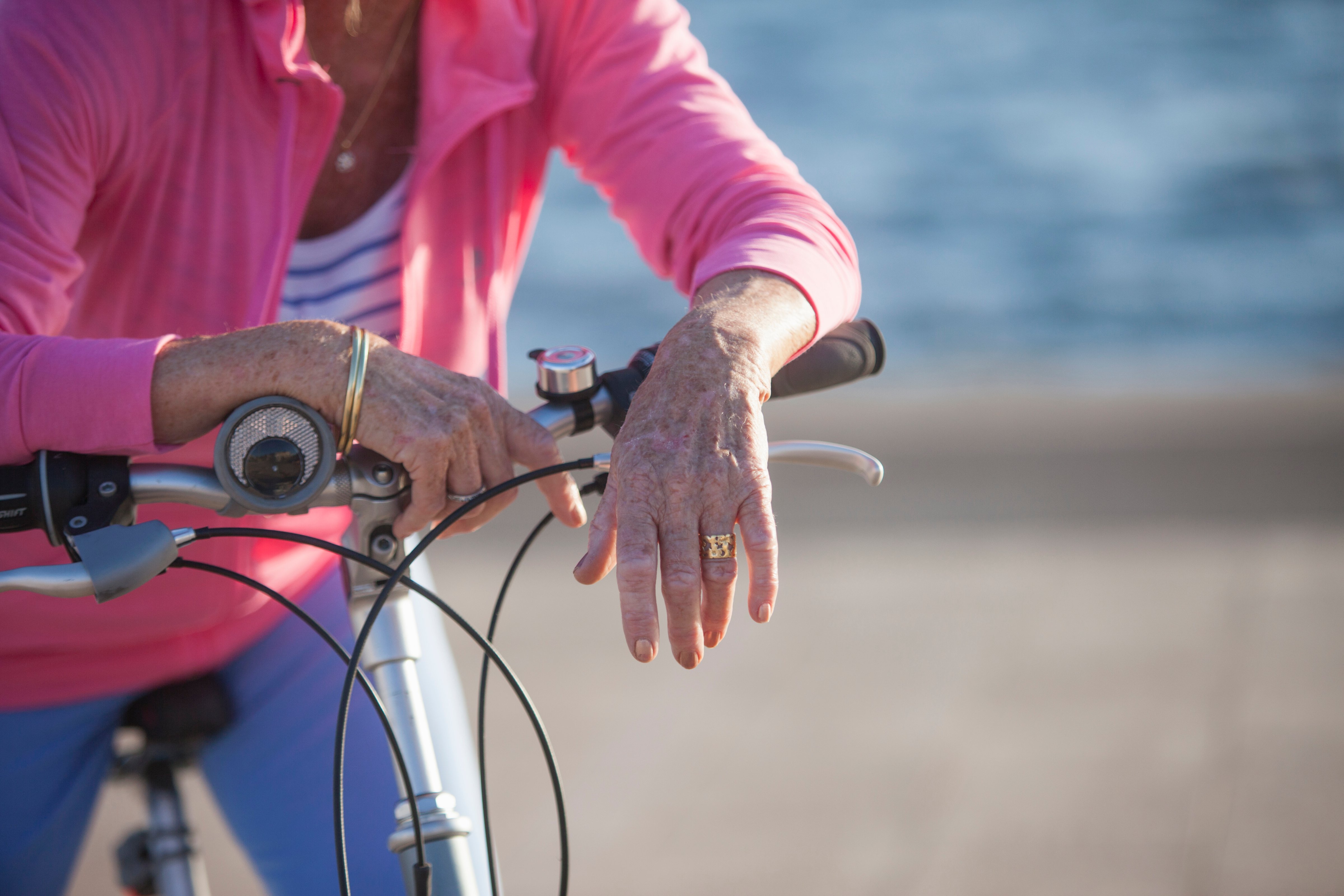 Senior woman on bicycle by beach