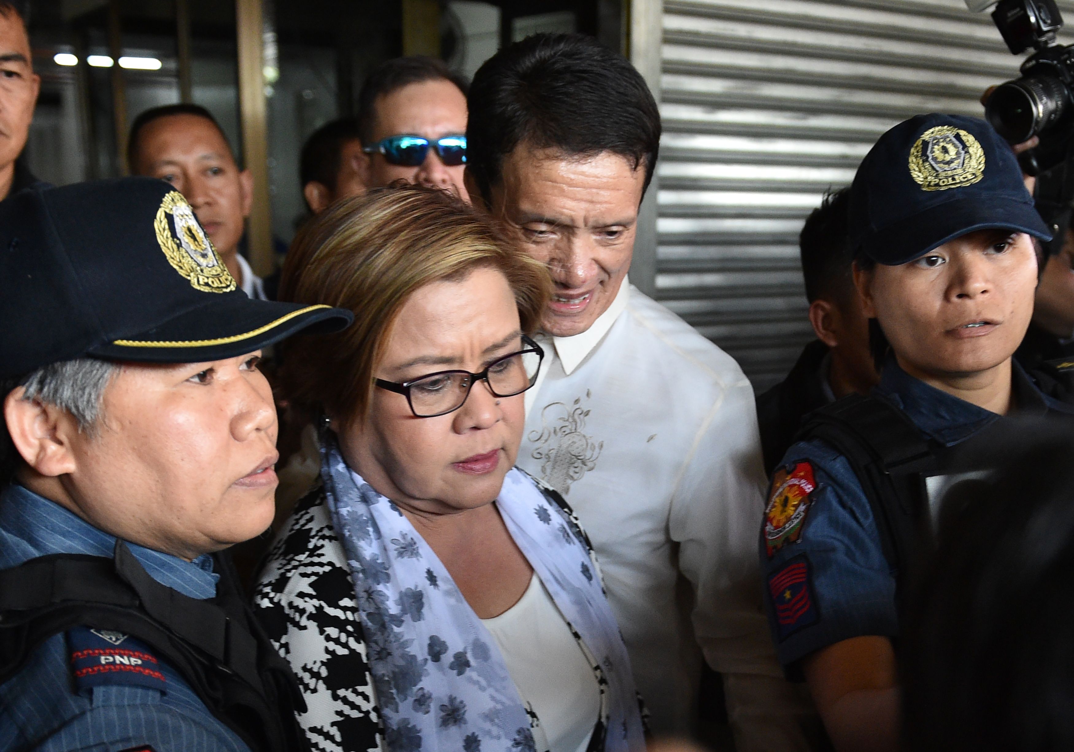 Philippine Senator Leila de Lima, center, a top critic of President Rodrigo Duterte, is escorted by police officers and her lawyer after her arrest at the Senate in Manila on Feb. 24, 2017 (Ted Aljibe—AFP/Getty Images)