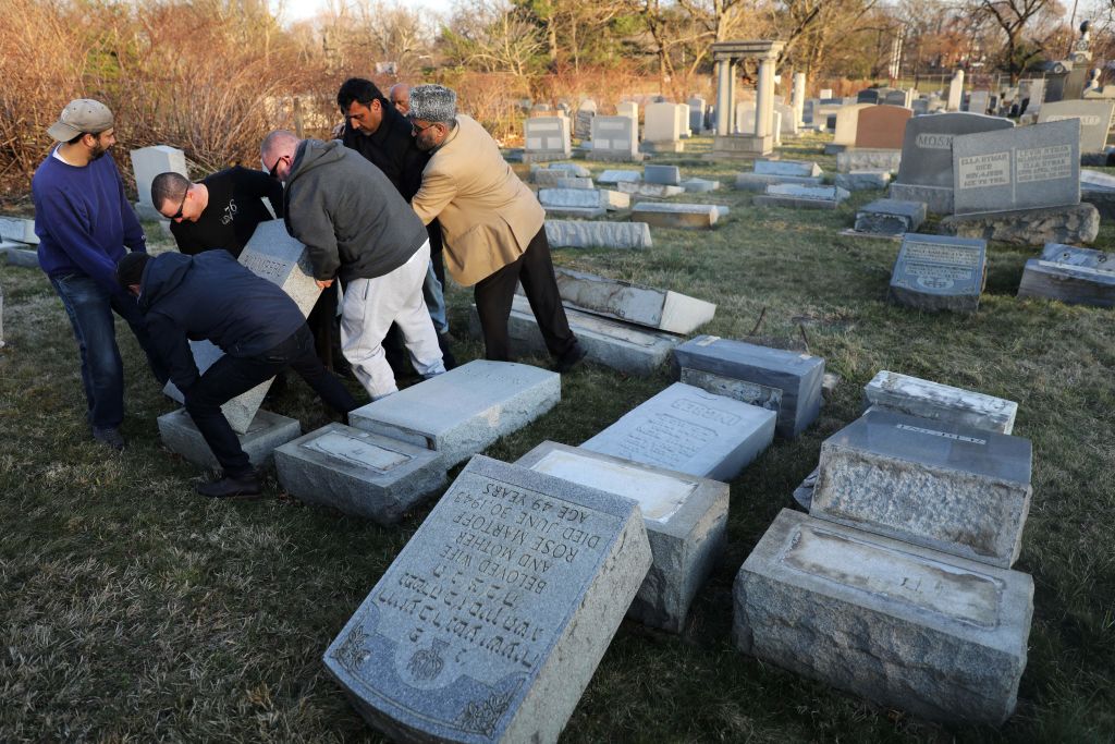 Volunteers help lift a fallen tombstone at the Jewish Mount Carmel Cemetery on Feb. 26, 2017, in Philadelphia. (DOMINICK REUTER&mdash;AFP/Getty Images)
