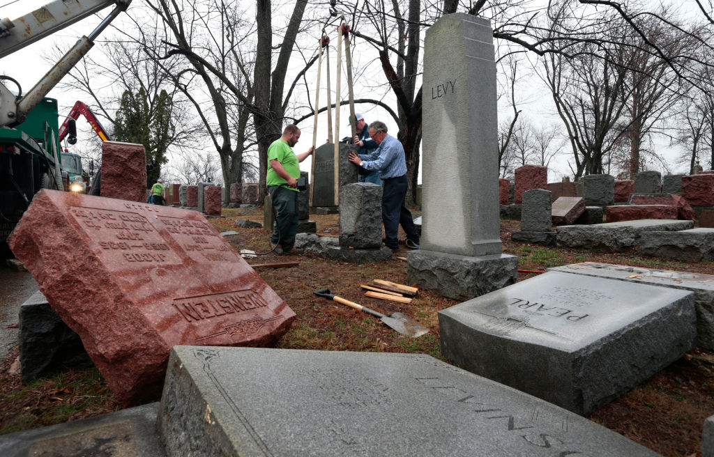 Spencer Pensoneau, left, Ron Klump and Philip Weiss of Rosenbloom Monument Company re-set stones at Chesed Shel Emeth Cemetery in University City on Feb. 21, 2017 where almost 200 gravestones were vandalized over the weekend in St. Louis. (St. Louis Post-Dispatch&mdash;TNS via Getty Images)