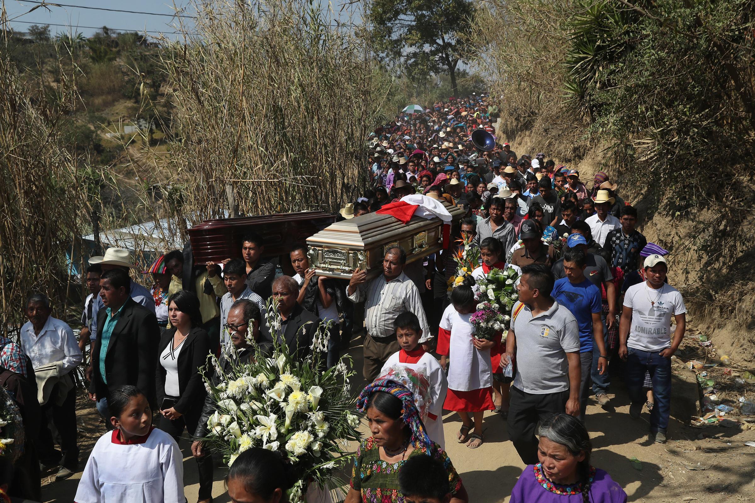 Relatives carry the caskets of two boys who were kidnapped and killed in San Juan Sacatepéquez on Feb. 14, 2017. More than 2,000 people walked in the funeral procession.