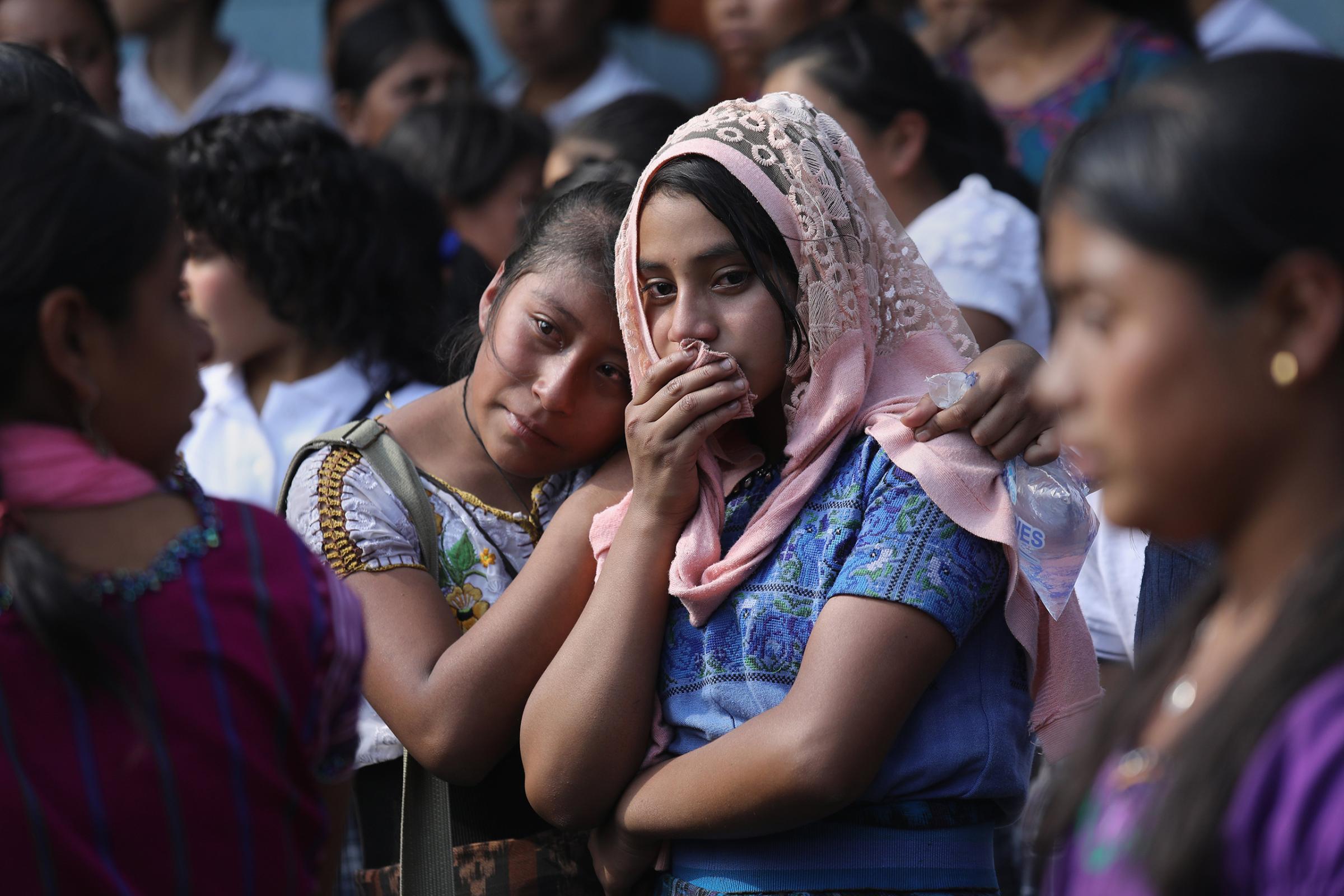 Two girls mourn at a memorial service held at the elementary school attended by two boys who were kidnapped and killed in San Juan Sacatepéquez, Guatemala, on Feb. 14, 2017.