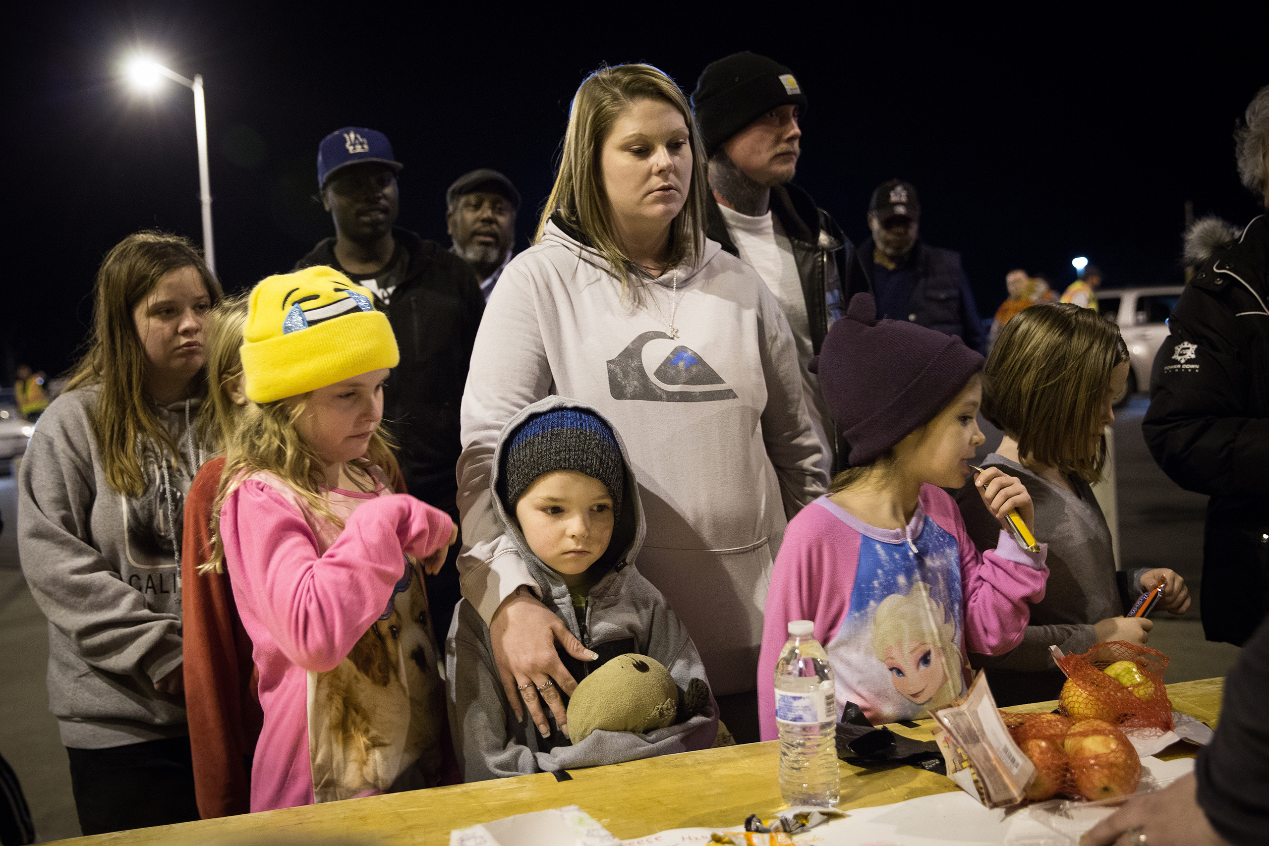 The McCaskill family of Oroville waits for more pizza to arrive outside the evacuation center at the Butte County Fairgrounds in Chico, Calif., on Feb. 12, 2017.