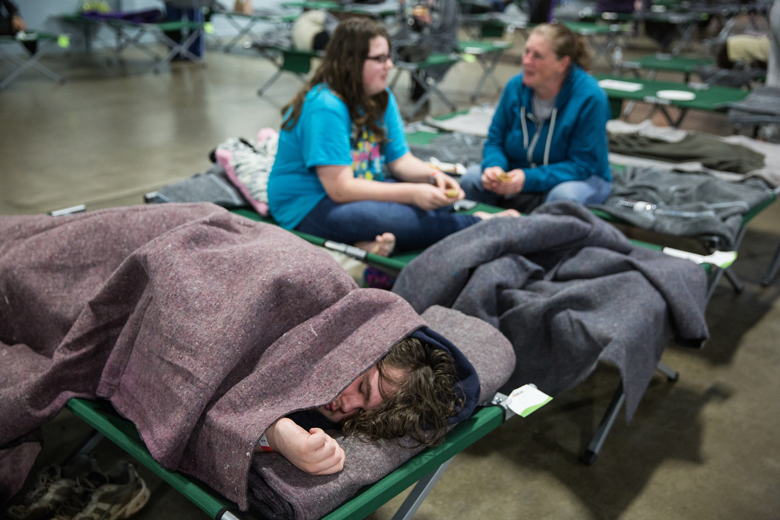 Donald Backovich, 15, of Oroville sleeps with his family at the evacuation center at the Butte County Fairgrounds in Chico, Calif., on Feb.12, 2017.