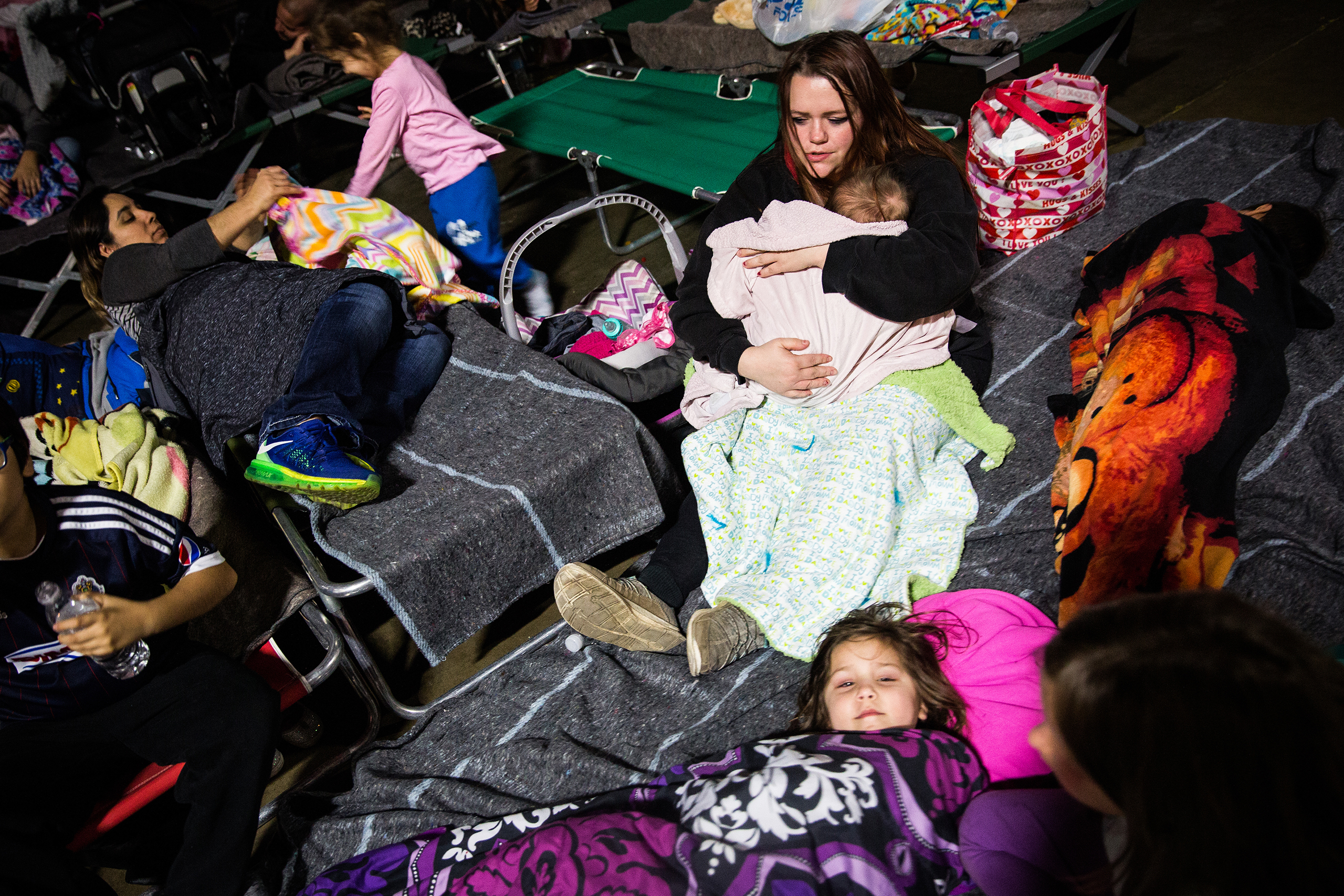 Gridley resident Shari Mota, right, tries to get her children to go to sleep in the evacuation center at the Butte County Fairgrounds in Chico, Calif., on Feb. 12, 2017.