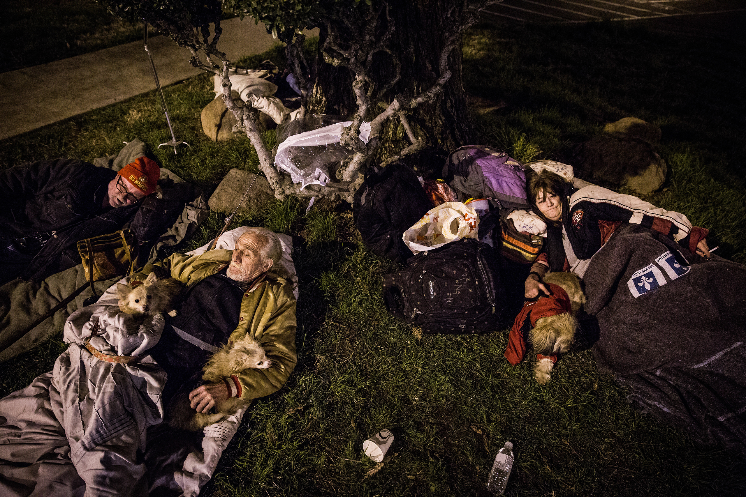 From left, Oroville residents Robert King, Jerry Lee Huggins and Anna Gibson sleep outside the evacuation center at the Butte County Fairgrounds in Chico, Calif., on Feb. 12, 2017.