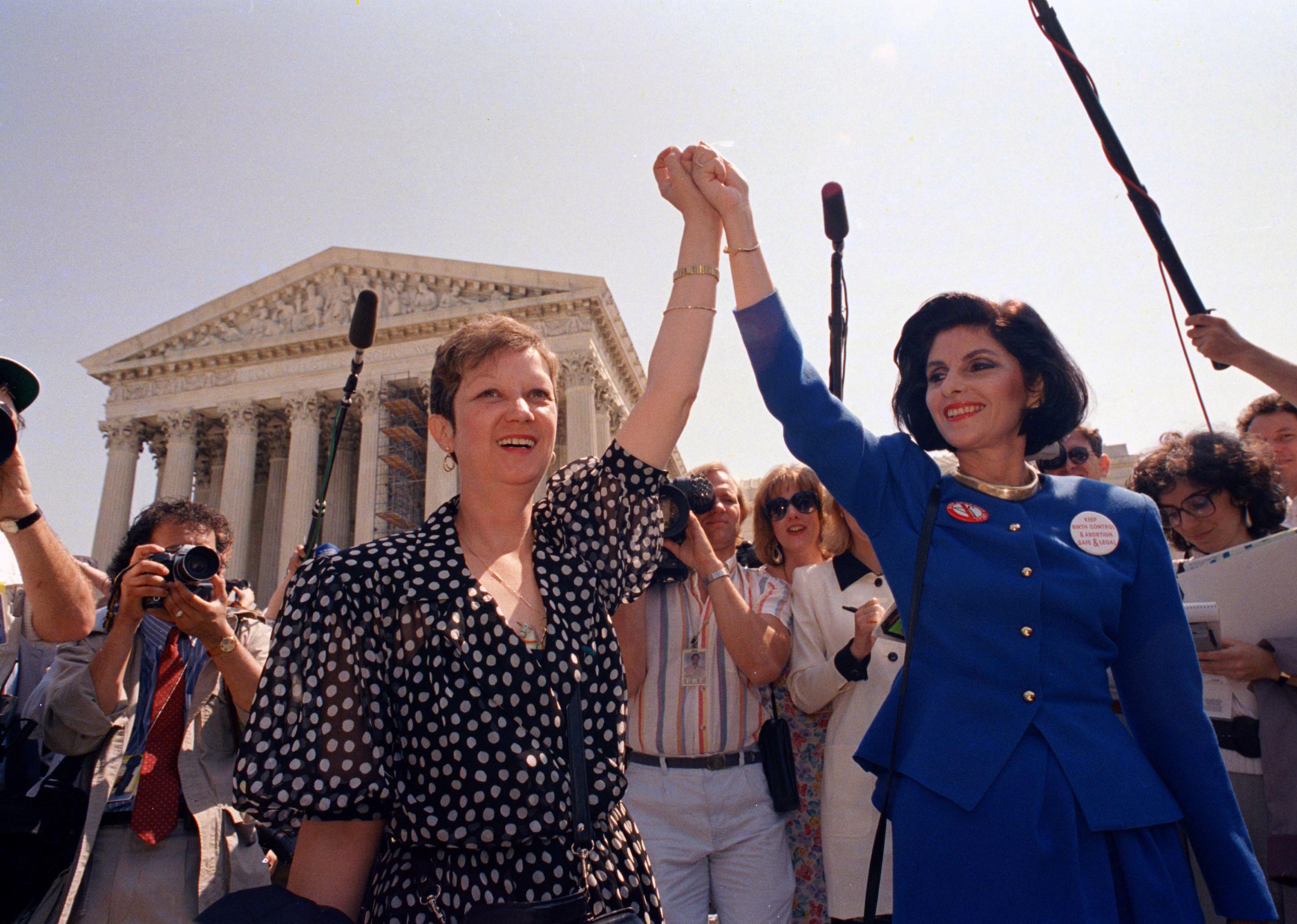 Norma McCorvey, Jane Roe in the 1973 court case, left, and her attorney Gloria Allred hold hands as they leave the Supreme Court building in Washington, DC., on April 26, 1989. (J. Scott Applewhite—AP)
