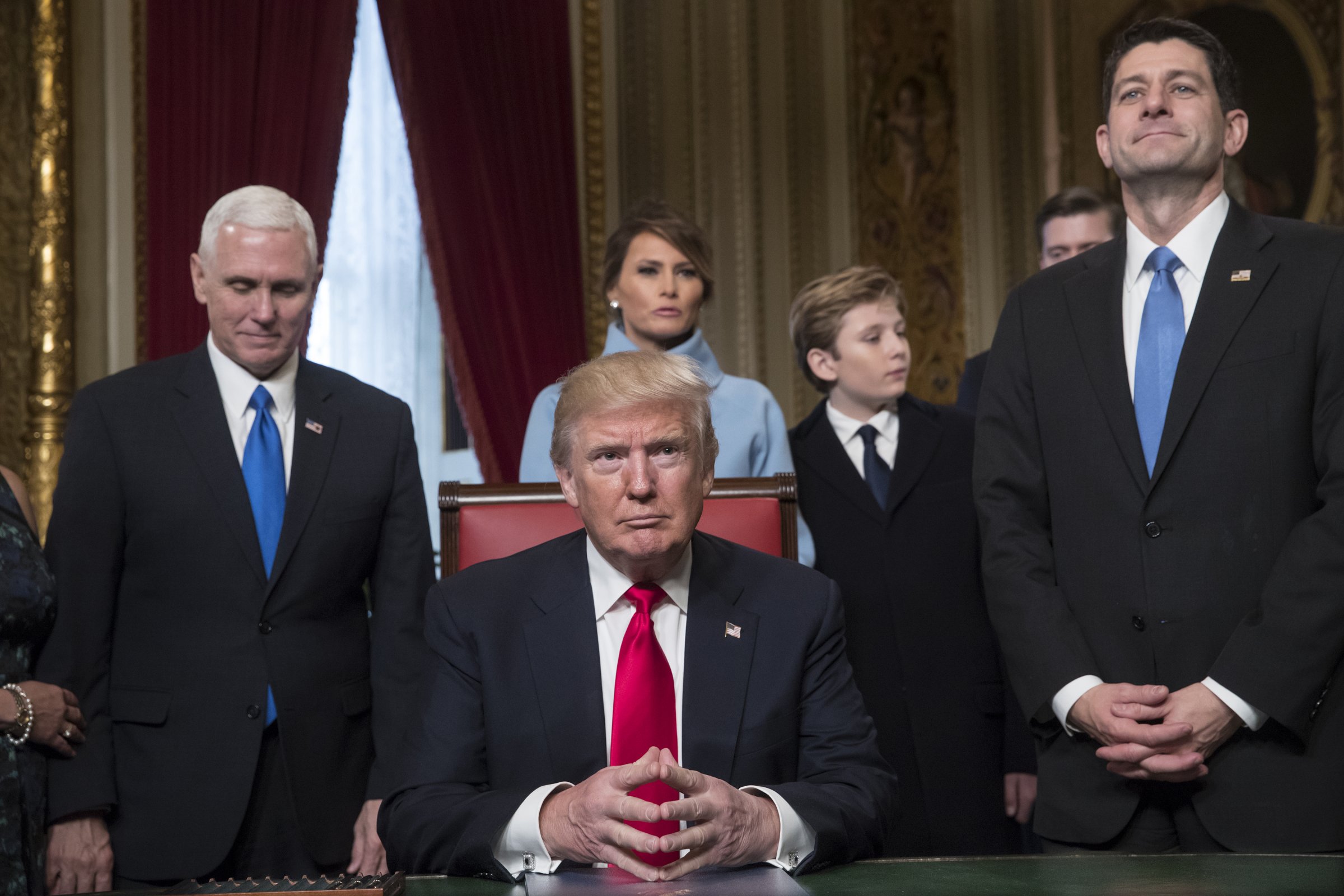 U.S. President Donald Trump, center, sits before formally signing his cabinet nominations into law with Vice President Mike Pence, left, and U.S. House Speaker Paul Ryan, a Republican from Wisconsin, during the 58th presidential inauguration in Washington, D.C., U.S., on Friday, Jan. 20, 2017.