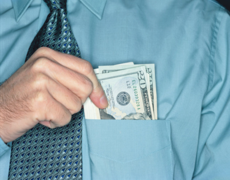 Man holding $20 bills in shirt pocket (Peter Dazeley/Getty Images)