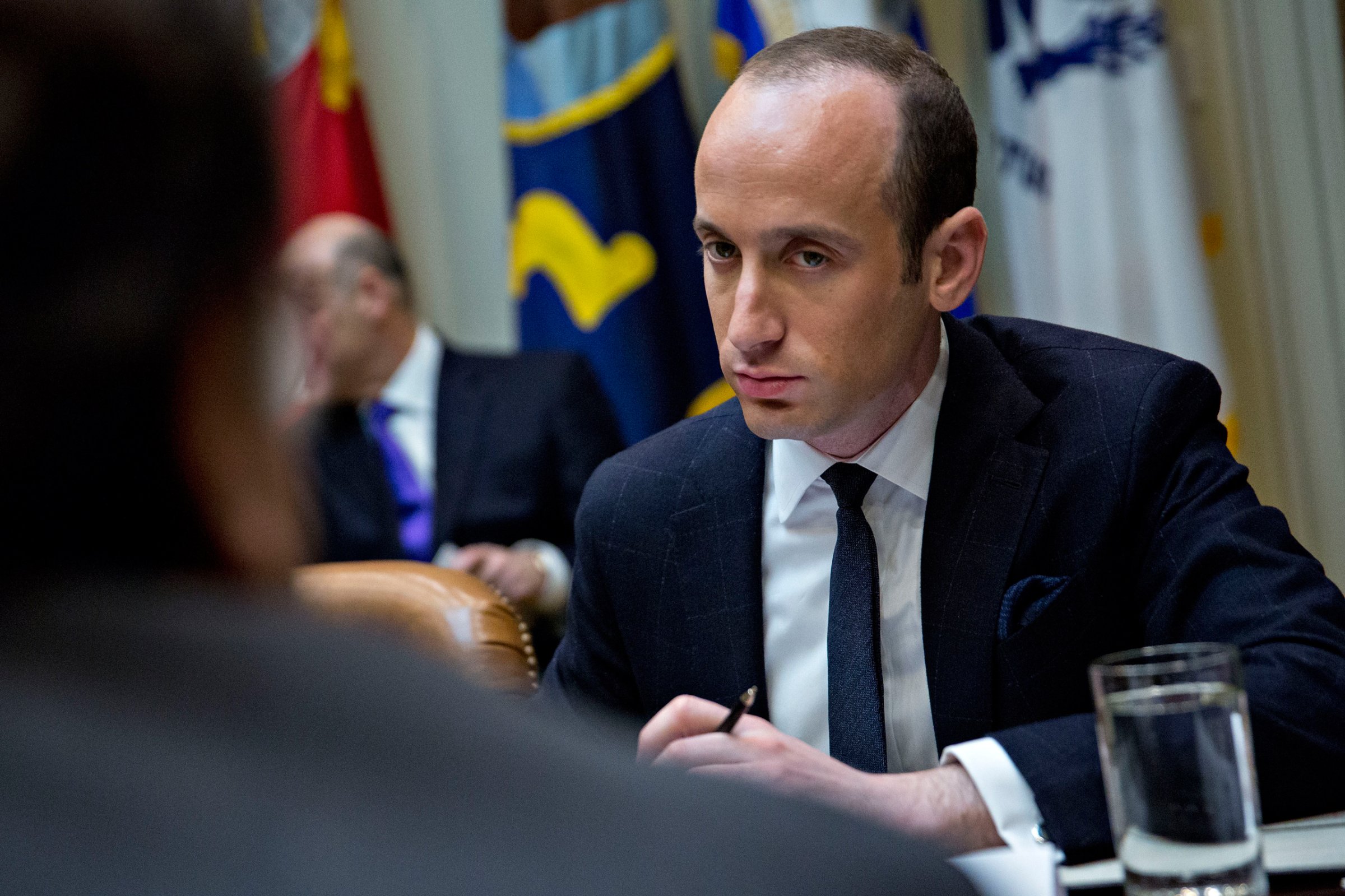 Stephen Miller, White House senior advisor for policy, right, listens as Roger Campos, with the Minority Business Roundtable, during a meeting of small business leaders with U.S. President Donald Trump, not pictured, in the Roosevelt Room of the White House in Washington, D.C., U.S., on Monday, Jan. 30, 2017. Trump defended the immigration clampdown that sparked a global backlash over the weekend by blaming the confusion at airports on protesters and on a computer outage at Delta Air Lines Inc. that caused flight cancellations. Credit: Andrew Harrer / Pool via CNP - NO WIRE SERVICE - Photo by: Andrew Harrer/picture-alliance/dpa/AP Images