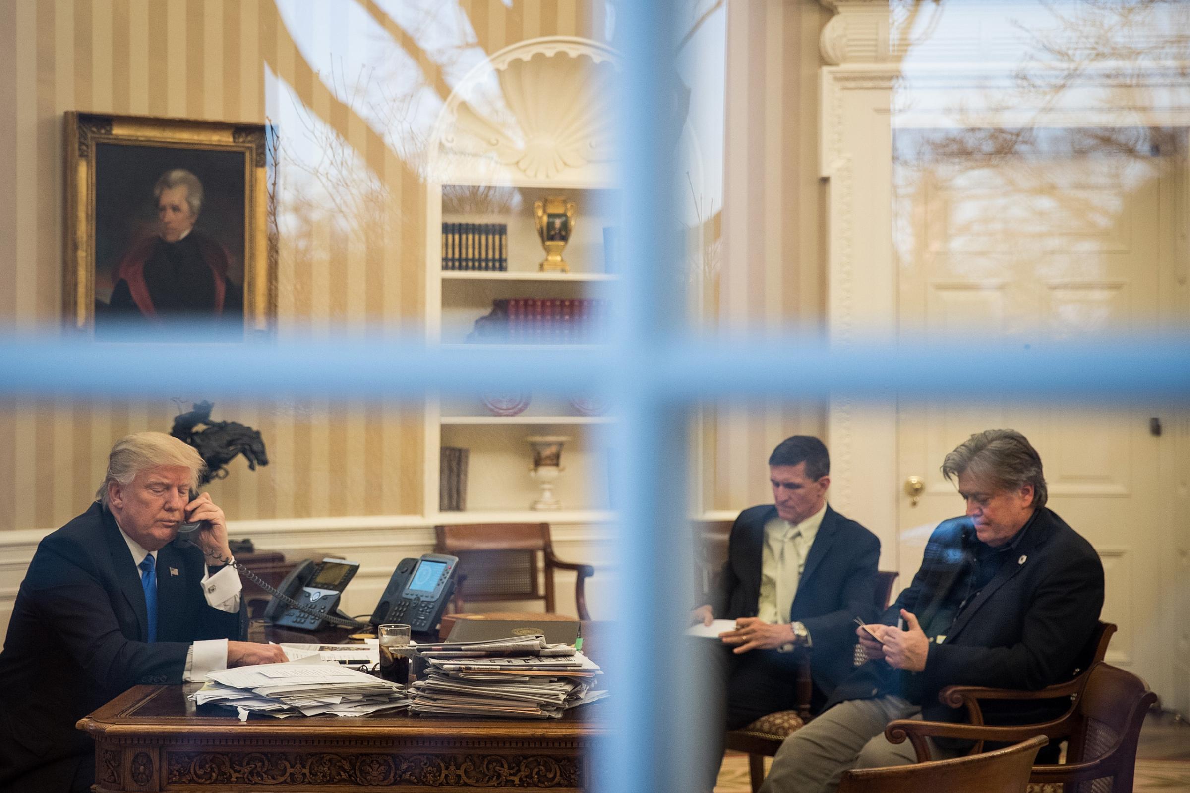 National security advisor Michael Flynn and White House chief strategist Steve Bannon in the Oval Office with President Trump while he speaks on the phone with Australian Prime Minister Malcolm Turnbull , Jan. 28, 2017.