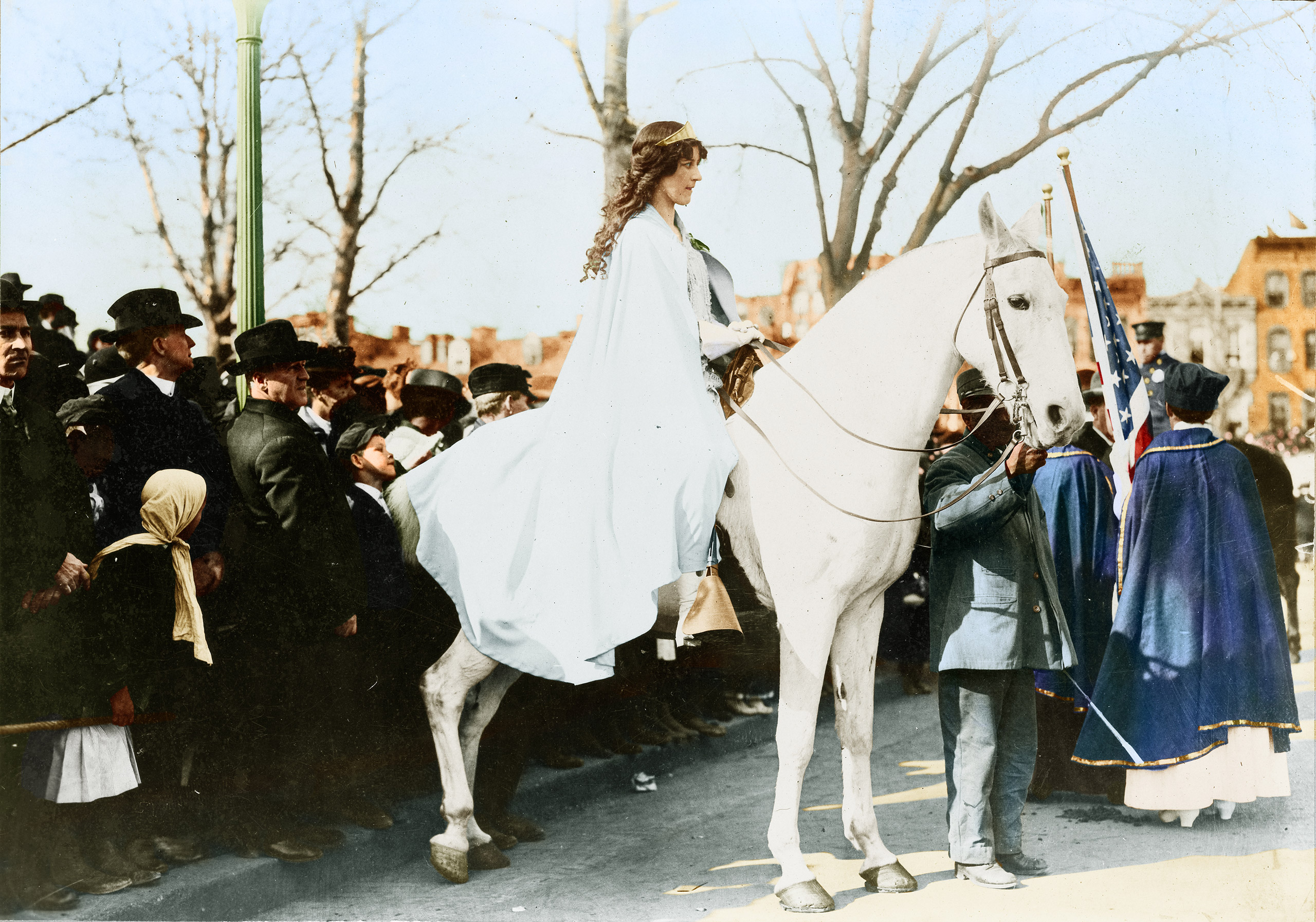 Inez Milholland Boissevain, wearing a white cape, seated on a white horse at the National American Woman Suffrage Association parade.