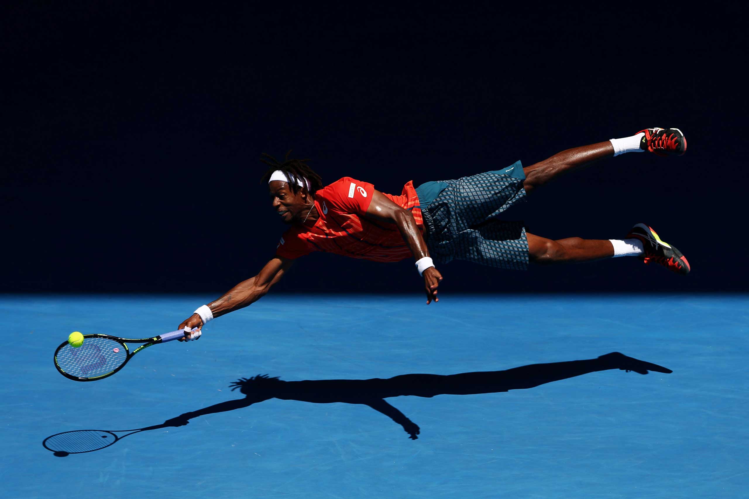 Gael Monfils of France dives for a forehand in his fourth round match against Andrey Kuznestov of Russia, during the 2016 Australian Open at Melbourne Park, Australia, on Jan. 25, 2016.