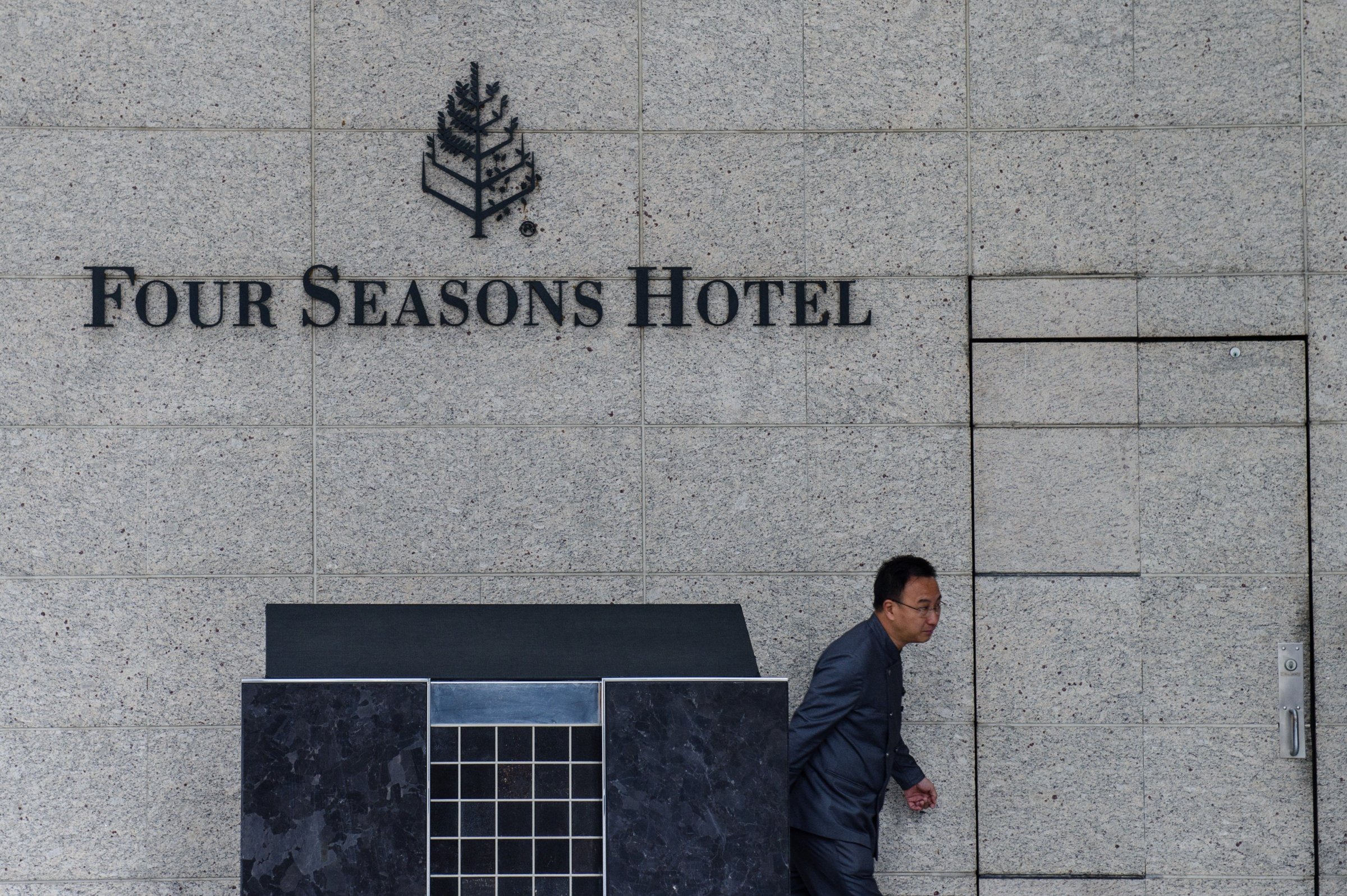 A member of staff walks outside the Four Seasons Hotel in Hong Kong on February 1, 2017. A Chinese billionaire has been abducted in Hong Kong by mainland agents, according to reports on January 31, triggering more concerns over security in the city after the disappearance of five booksellers.