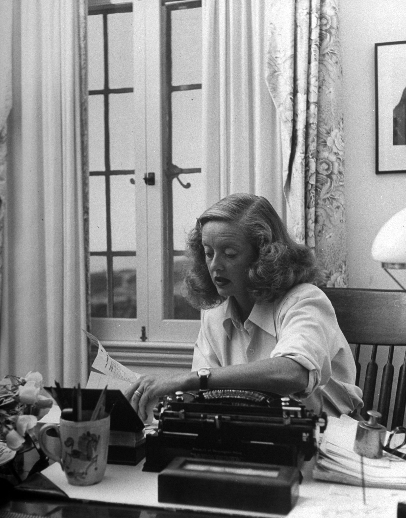 Bette Davis working at her desk at home in California, 1947.