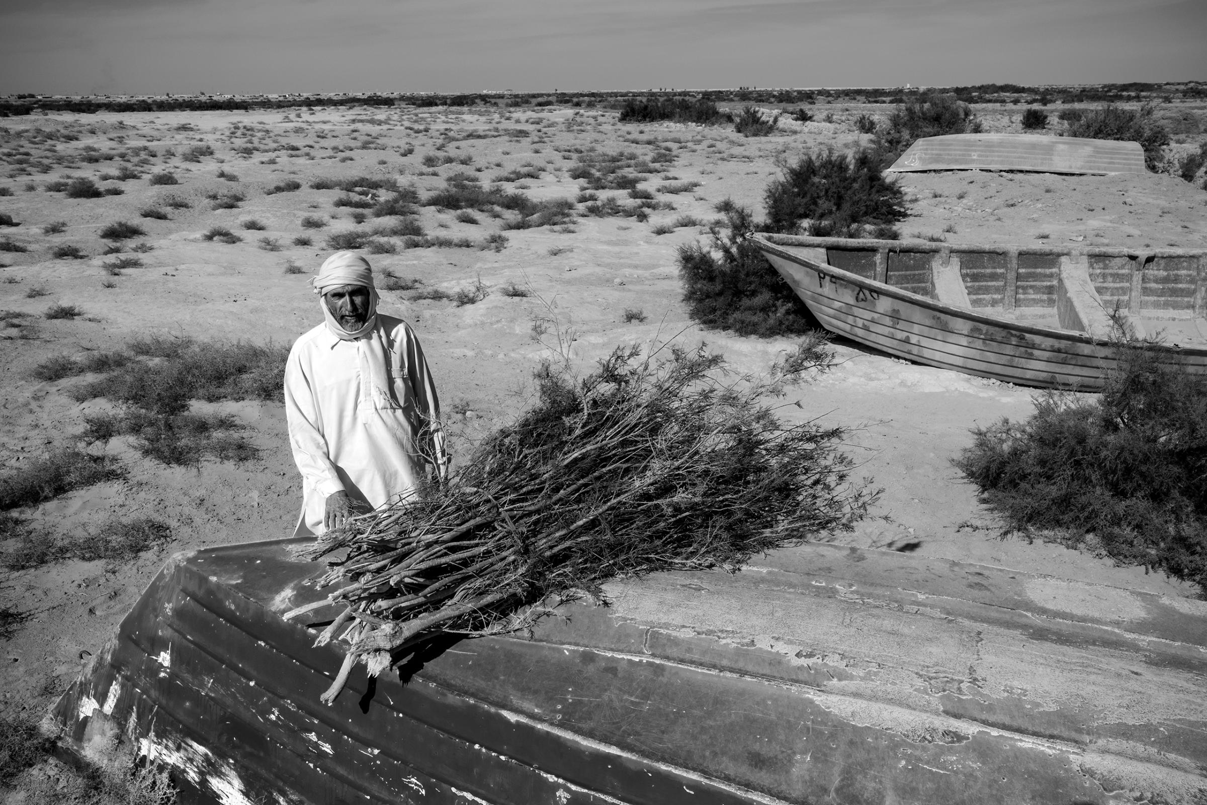 A fisherman sells tamarisk reeds in the dried-out seabed of Lake Hamoon.  At the border between Iran and Afghanistan, the Sistan Basin is one of the most arid places in the world. Drought and mismanagement of irrigation contributed to drying out the lake, thereby impacting wildlife and the livelihood of the local population, December 2016.