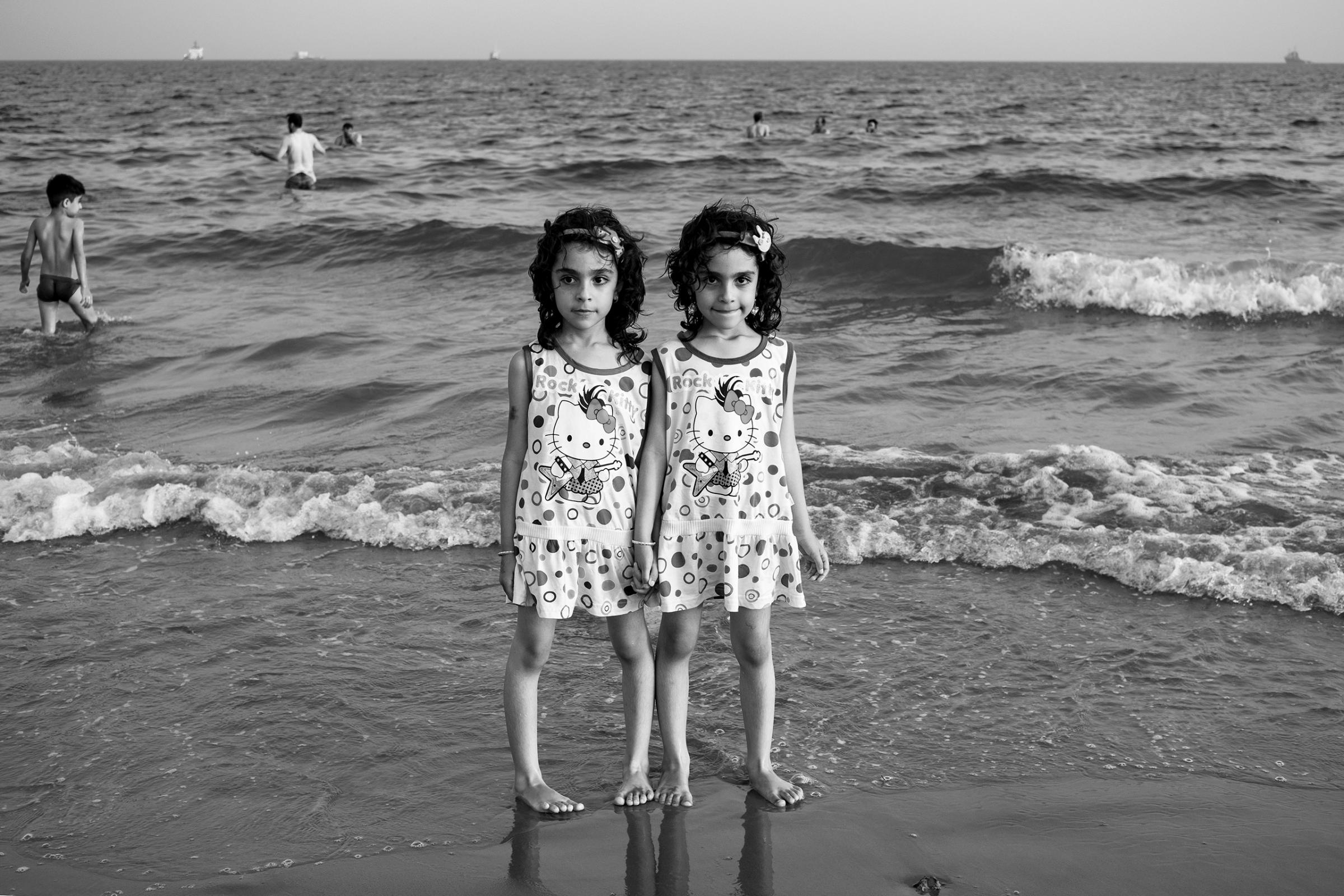 Twins escape from high temperatures  at the seaside of Dayyer, Iran.  According to scientists, by 2070, if worldwide emissions arenÕt sufficiently reduced, the Persian Gulf will experience heat waves that will be impossible for many humans to survive, May 2016.