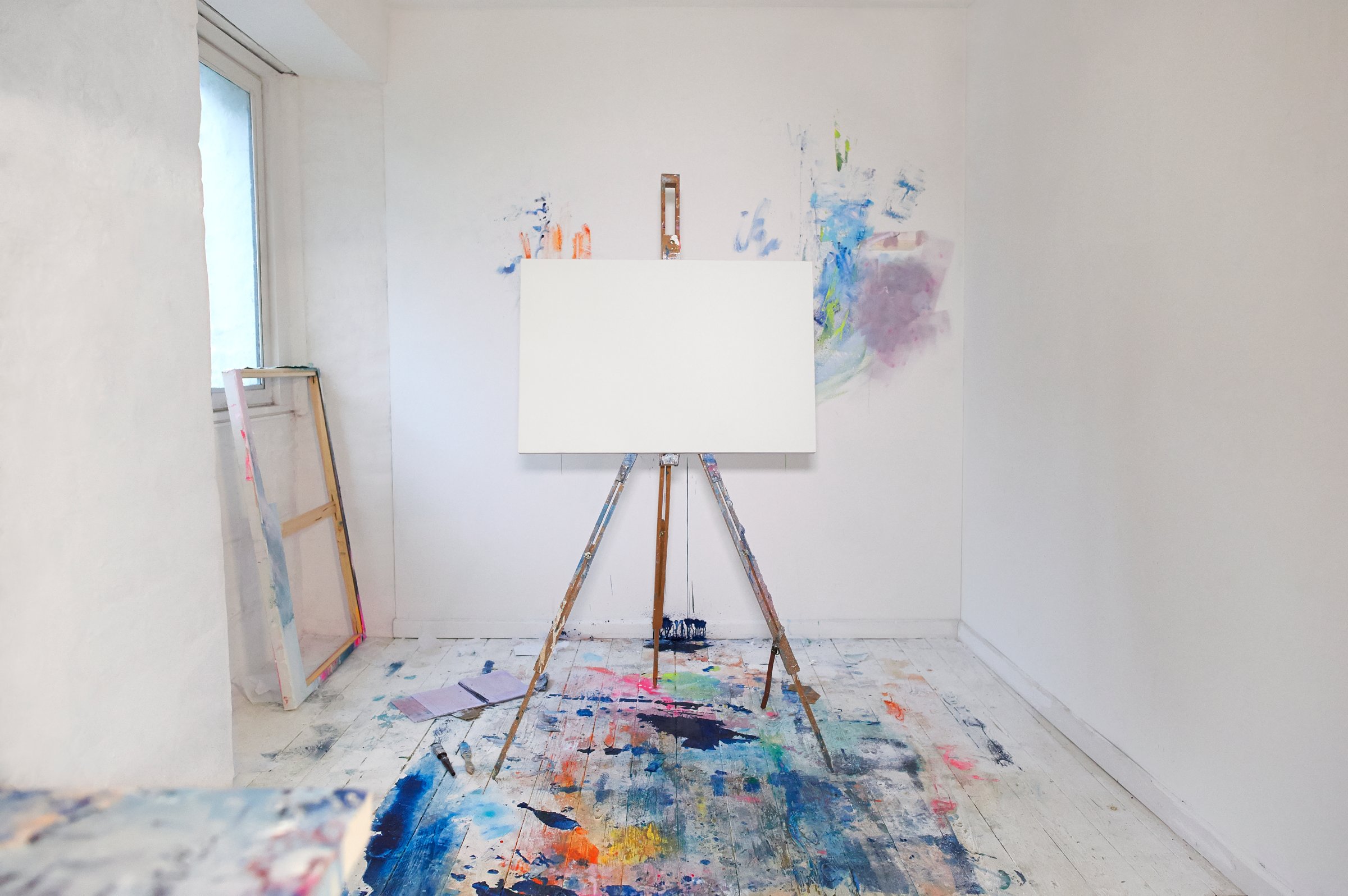 Blank canvas on easel and paint in artist studio.