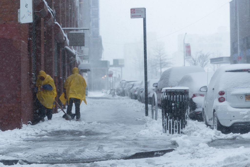 Snow shovellers cower from the wind as strong gusts and snow take hold in Brooklyn, on February 09, 2017 in New York City. (Barcroft Media—Barcroft Media via Getty Images)