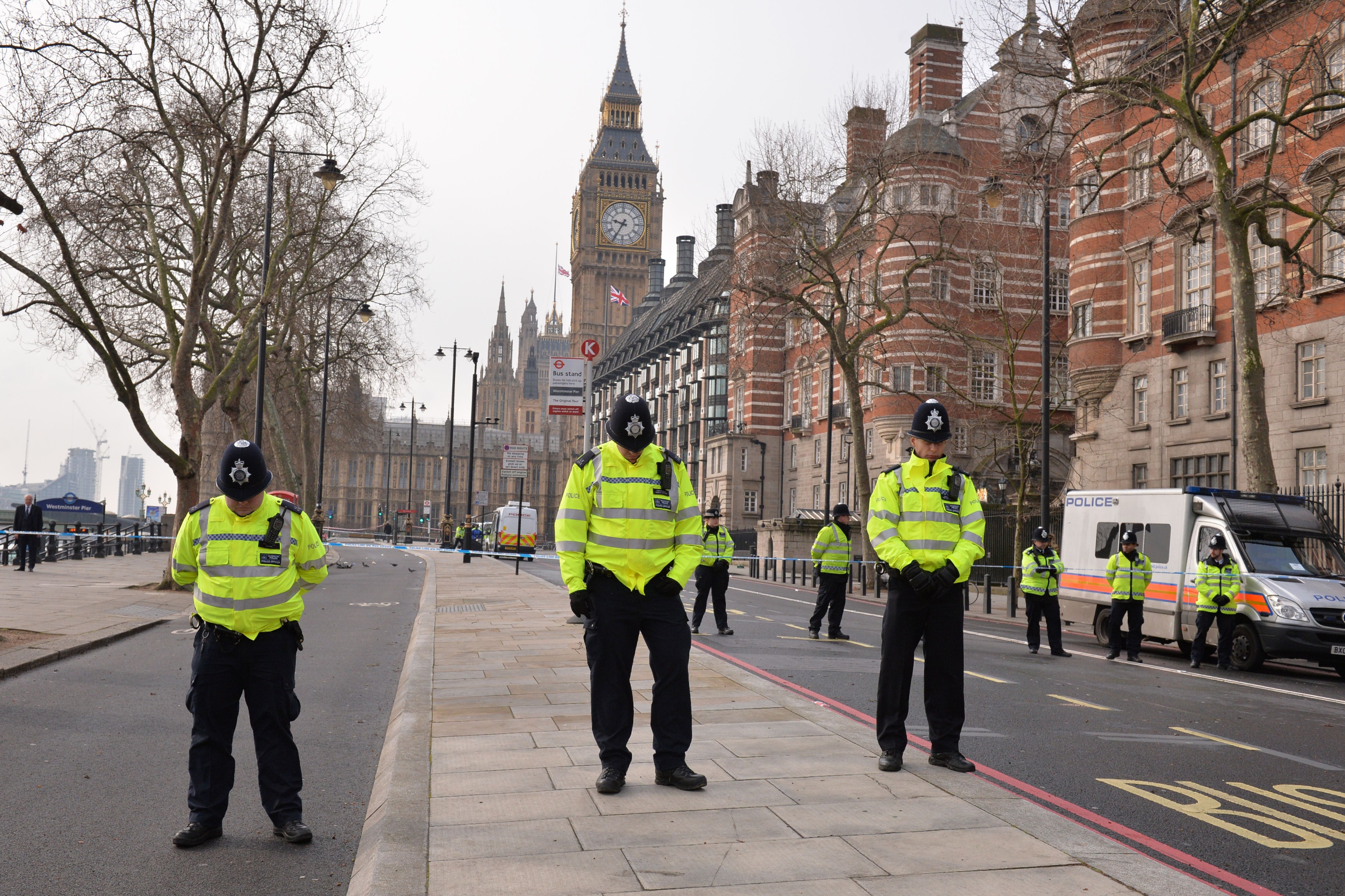 British police officers bow their heads as they stand near a police cordon directly outside New Scotland Yard and within sight of the Houses of Parliament in central London on March 23, 2017. (Justin Tallis—AFP/Getty Images)