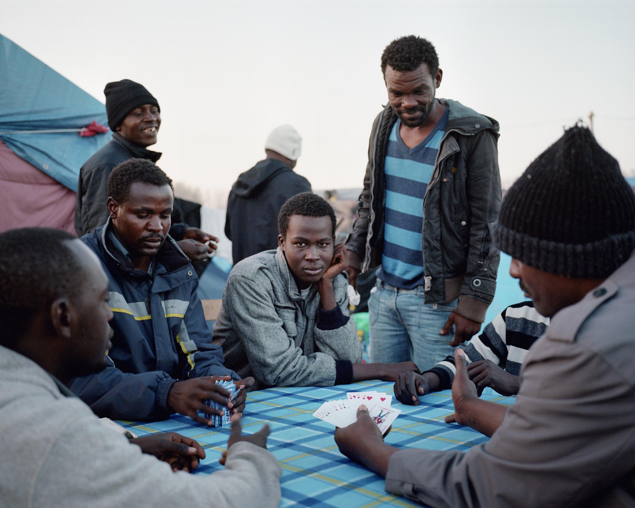 Sudanese men play cards to pass the time in the Calais "Jungle".