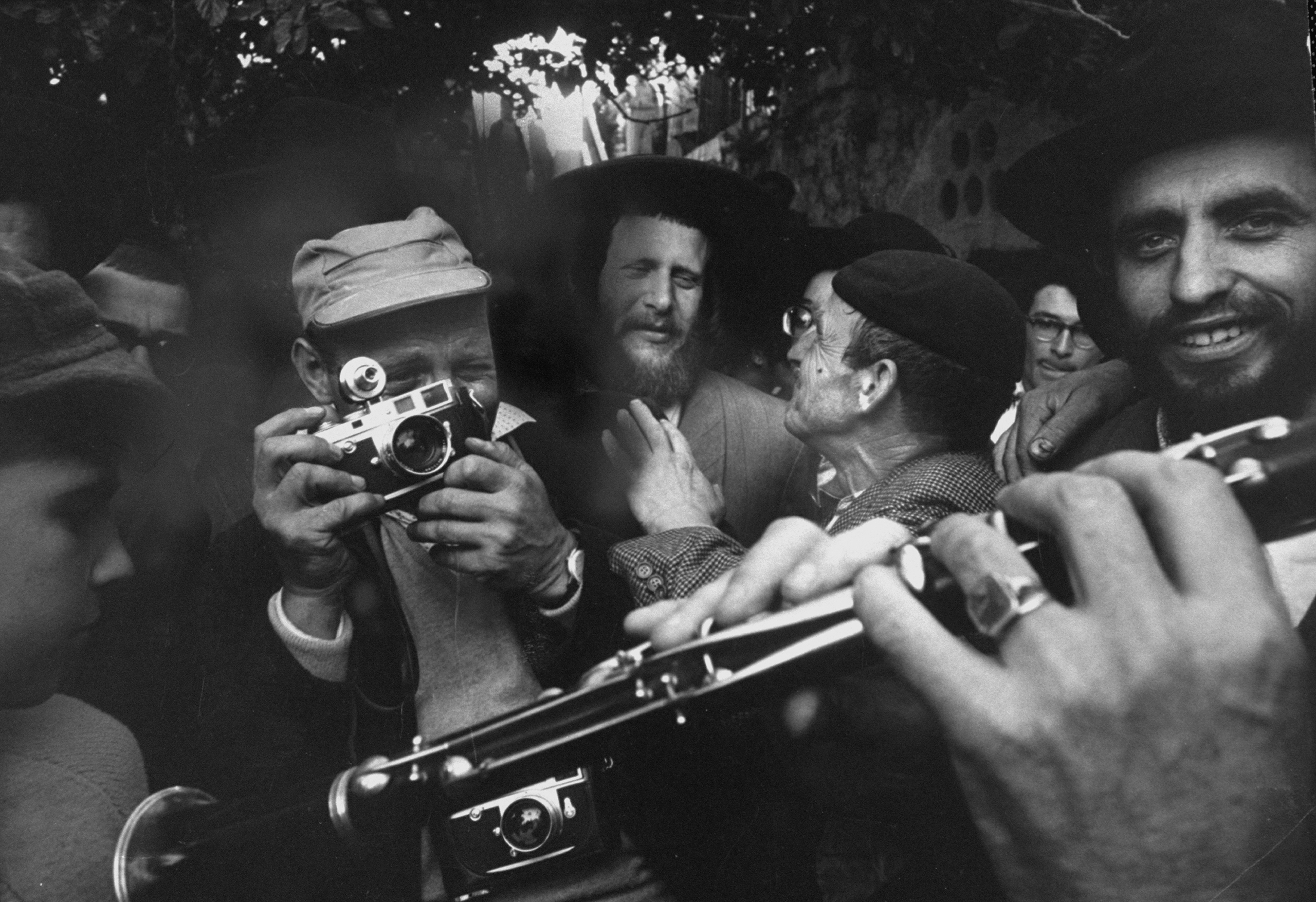 David Rubinger (center L), taking photographs at a religious festival in Israel. (Paul Schutzer—The LIFE Picture Collection/Getty images)
