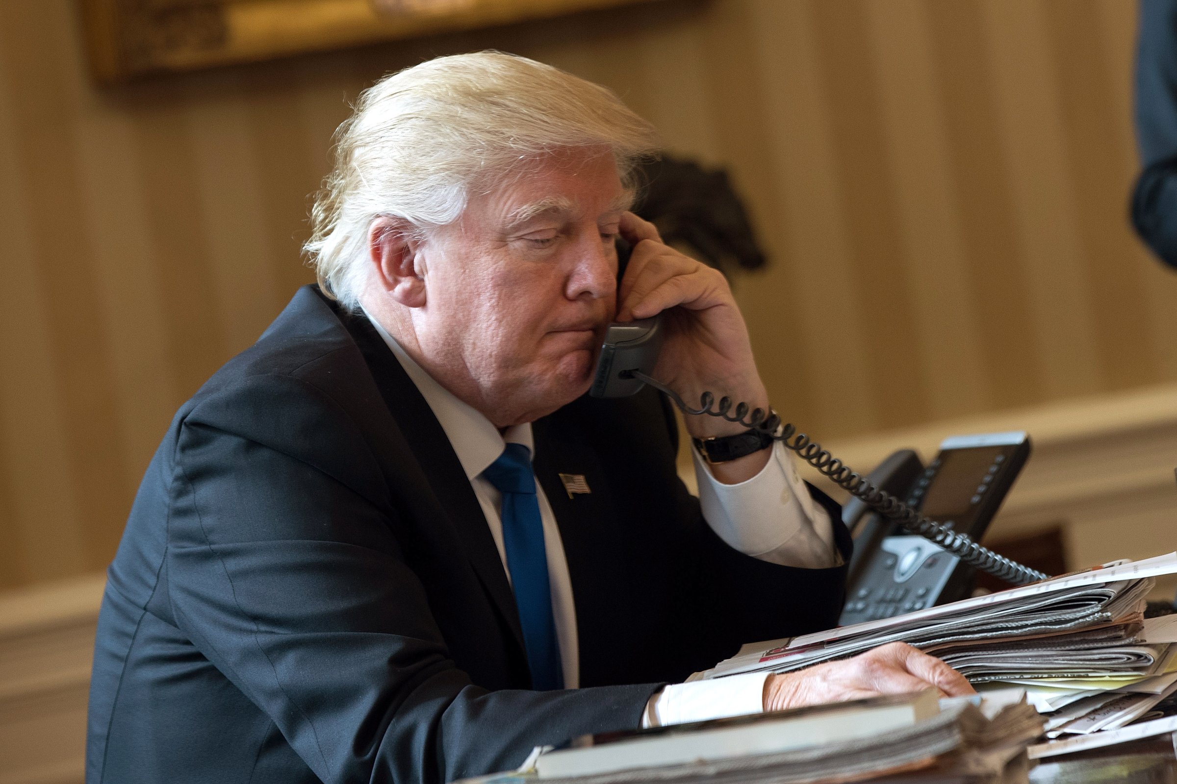 President Donald Trump speaks on the phone with Russian President Vladimir Putin in the Oval Office of the White House, January 28, 2017 in Washington, DC.