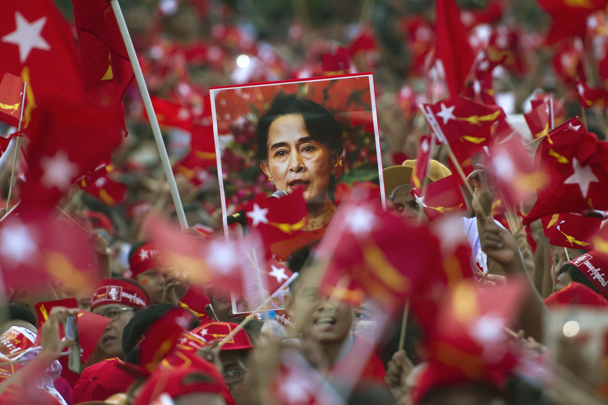 Supporters of opposition leader Aung San Suu Kyi hold posters bearing her image as they listen during a campaign speech in Yangon on Nov. 1, 2015.