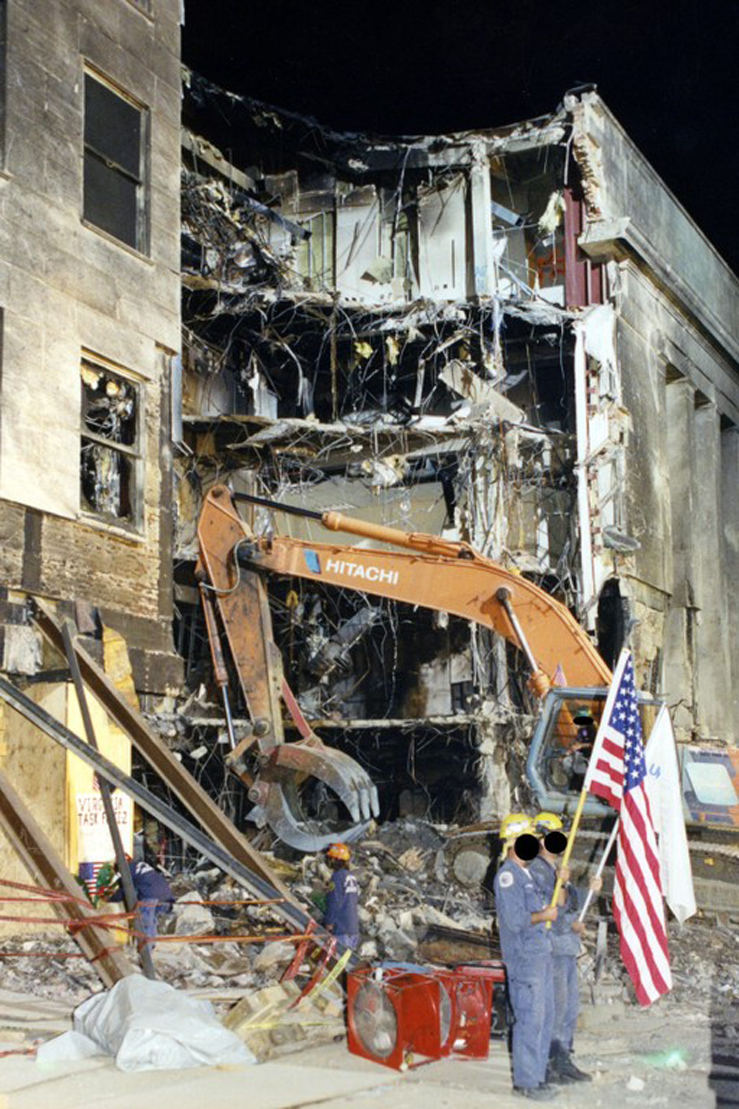 Members of the emergency services holding a US flag after the hijacked American Airlines Flight 77 crashed into the Pentagon in Arlington County, Virginia, on Sept. 11, 2001.