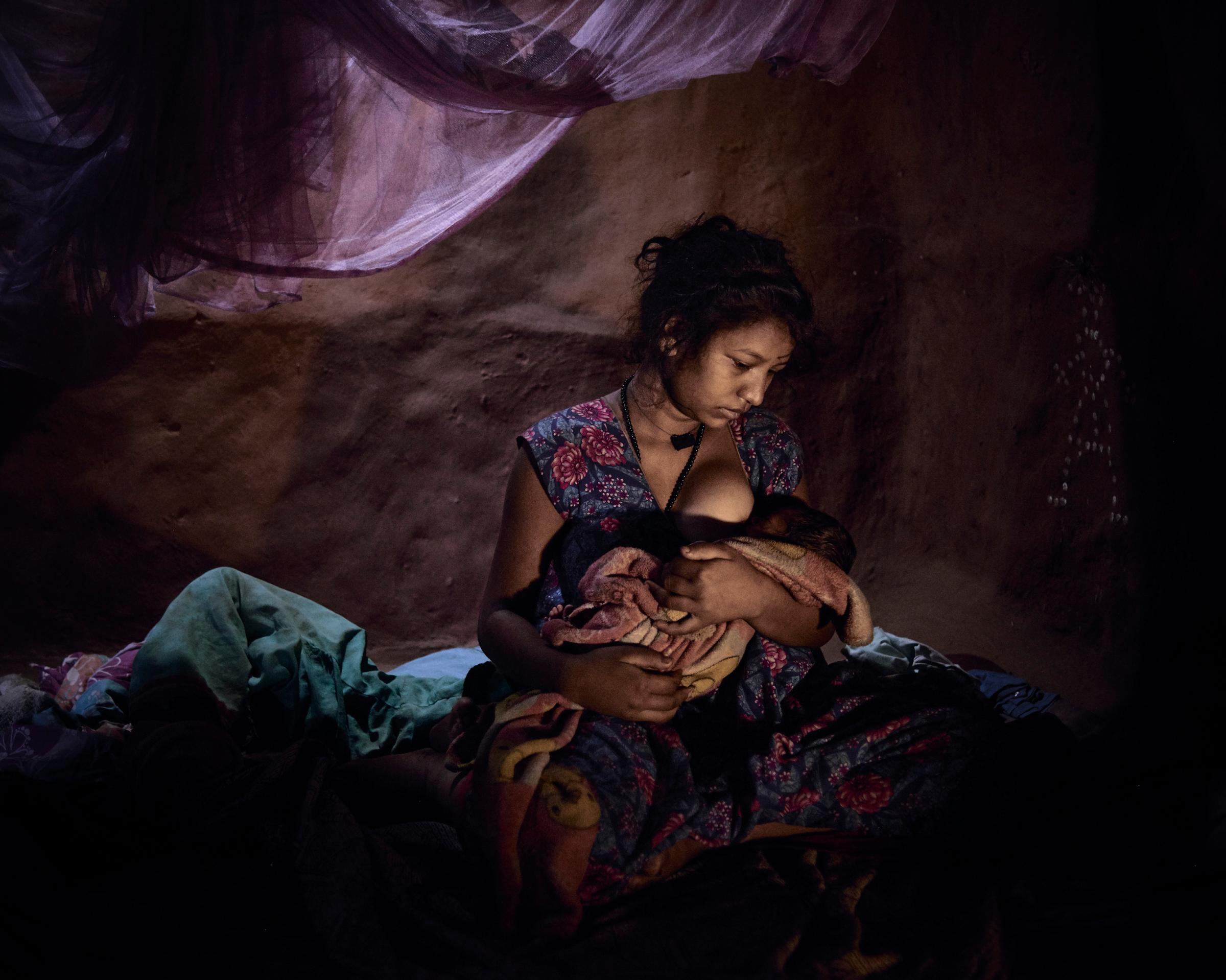 Saraswati, 16, must live in a closed dark room with her three day old baby because she bled after childbirth.