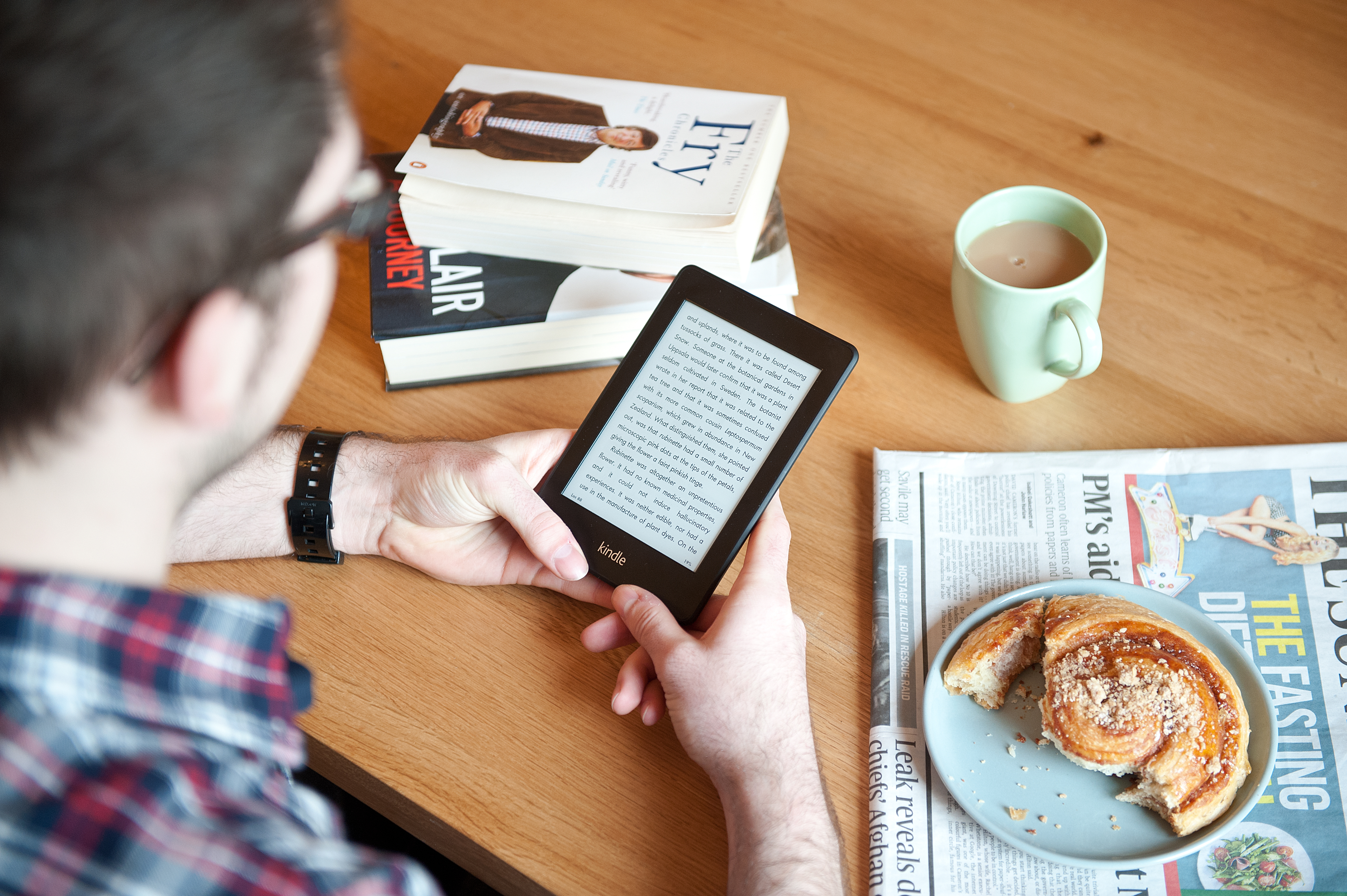 A close-up of a man using a Kindle Paperwhite e-reader whilst enjoying morning coffee, January 17, 2013. (Future Publishing&mdash;Future Publishing)