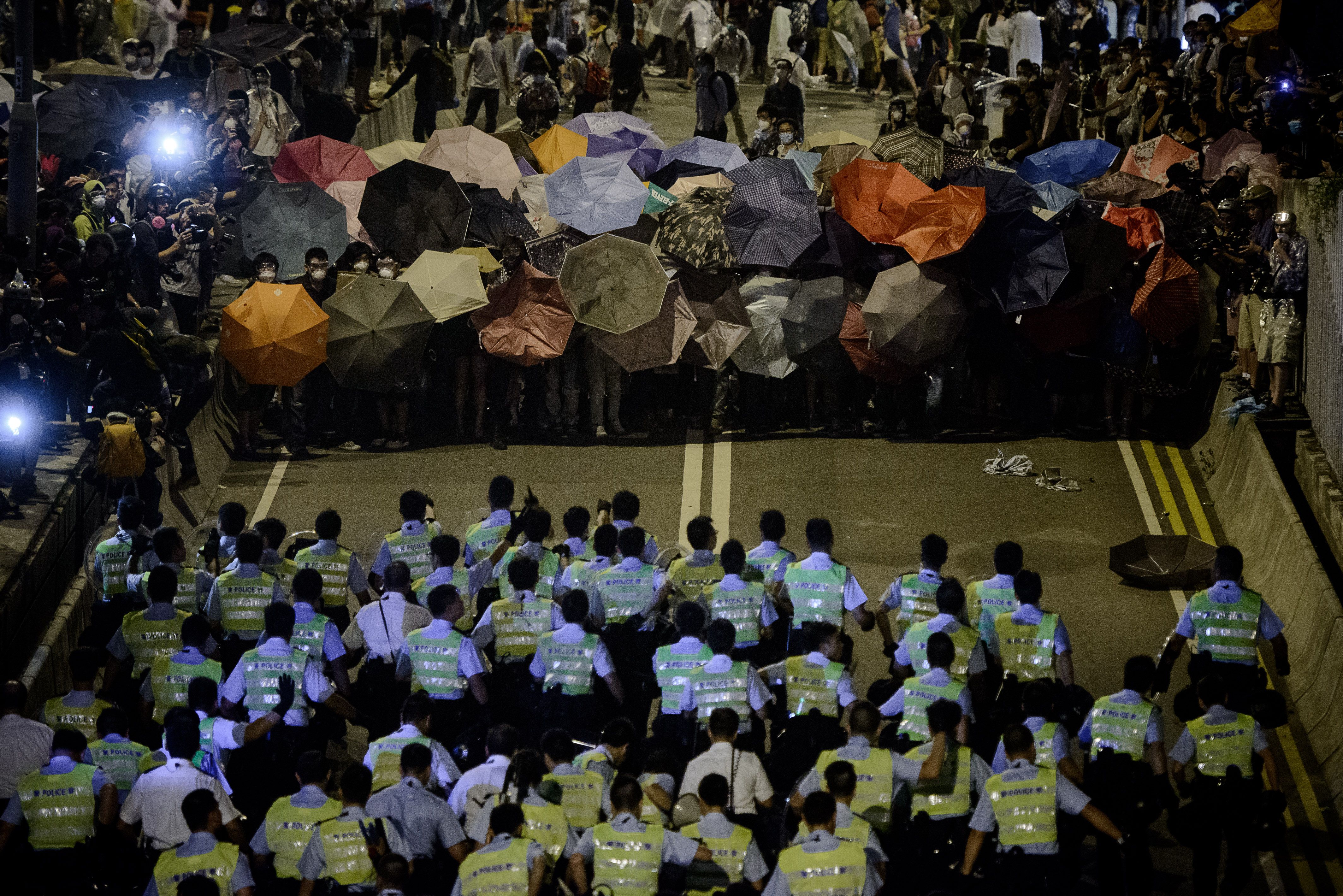Police forces march toward pro-democracy protesters during a standoff outside the central government offices in Hong Kong on Oct. 14, 2014 (Philippe Lopez—AFP/Getty Images)
