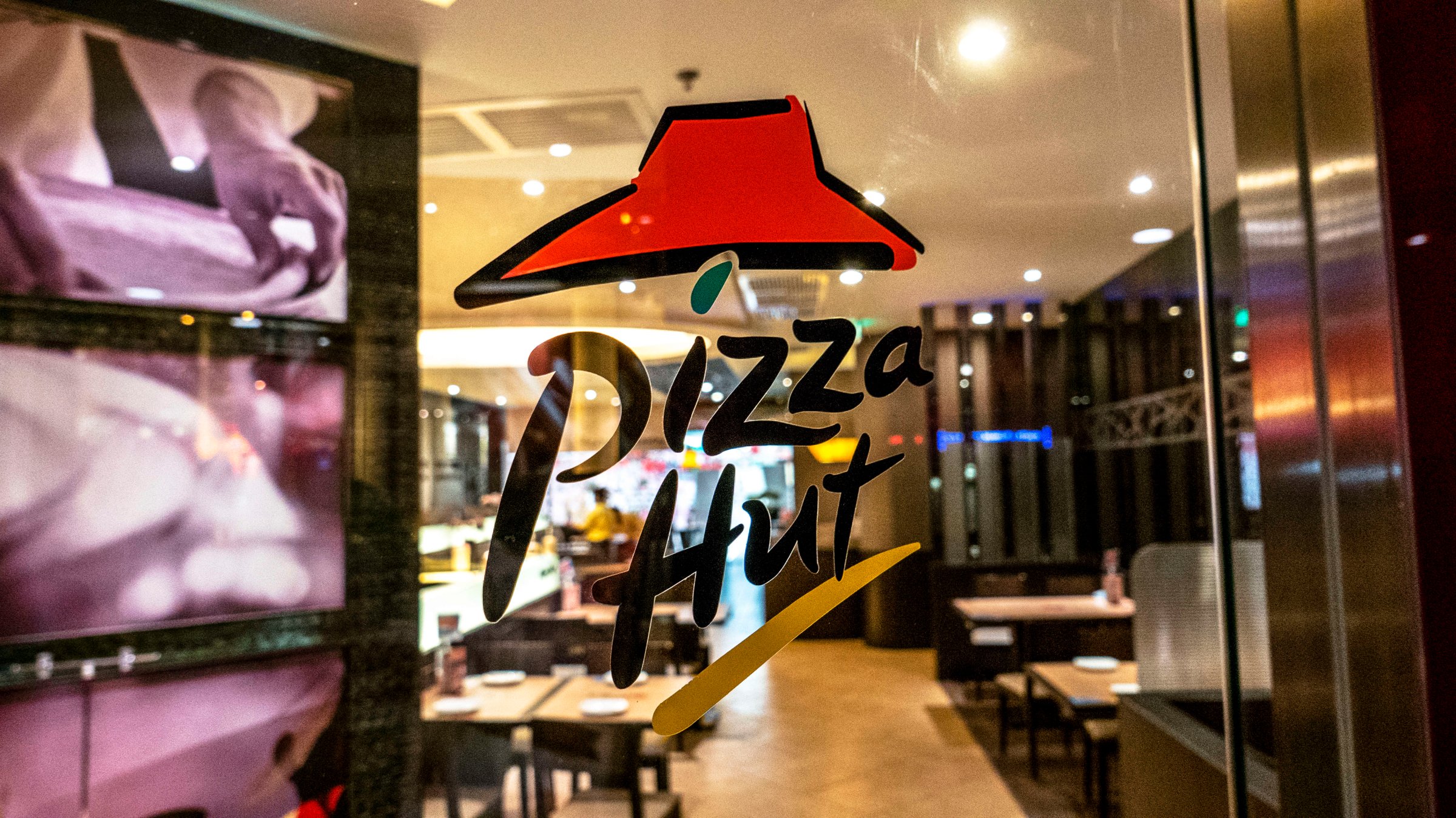 Pizza Hut logo on the window of a Pizza Hut restaurant.