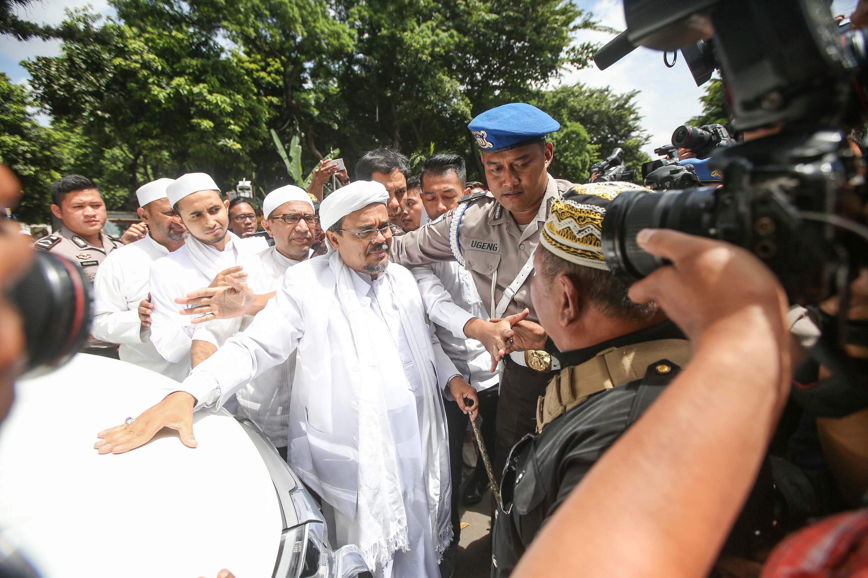 Leader of the Islamic Defenders Front (FPI), Habib Rizieq Shihab, is escorted by police at police headquarters for questioning, on Jan. 23, 2017, in Jakarta (Jefta Images—Barcroft Media/Getty Images)